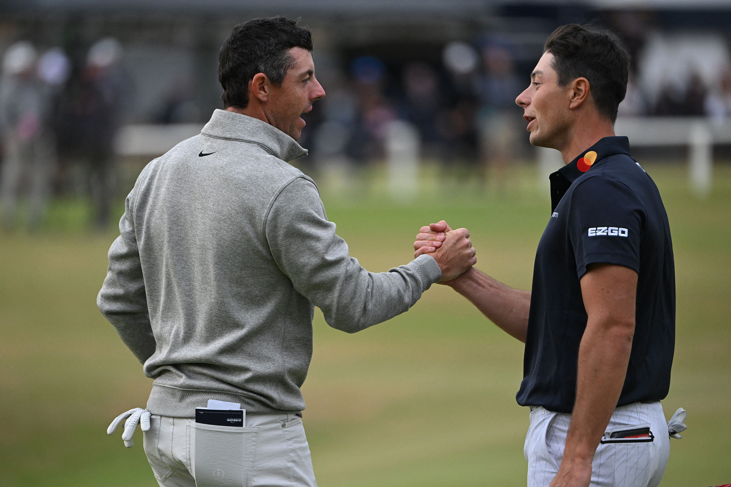 Viktor Hovland, (right) and Rory McIlroy shake hands on the 18th green after their third rounds of The 150th Open at St Andrews. Photo: AFP