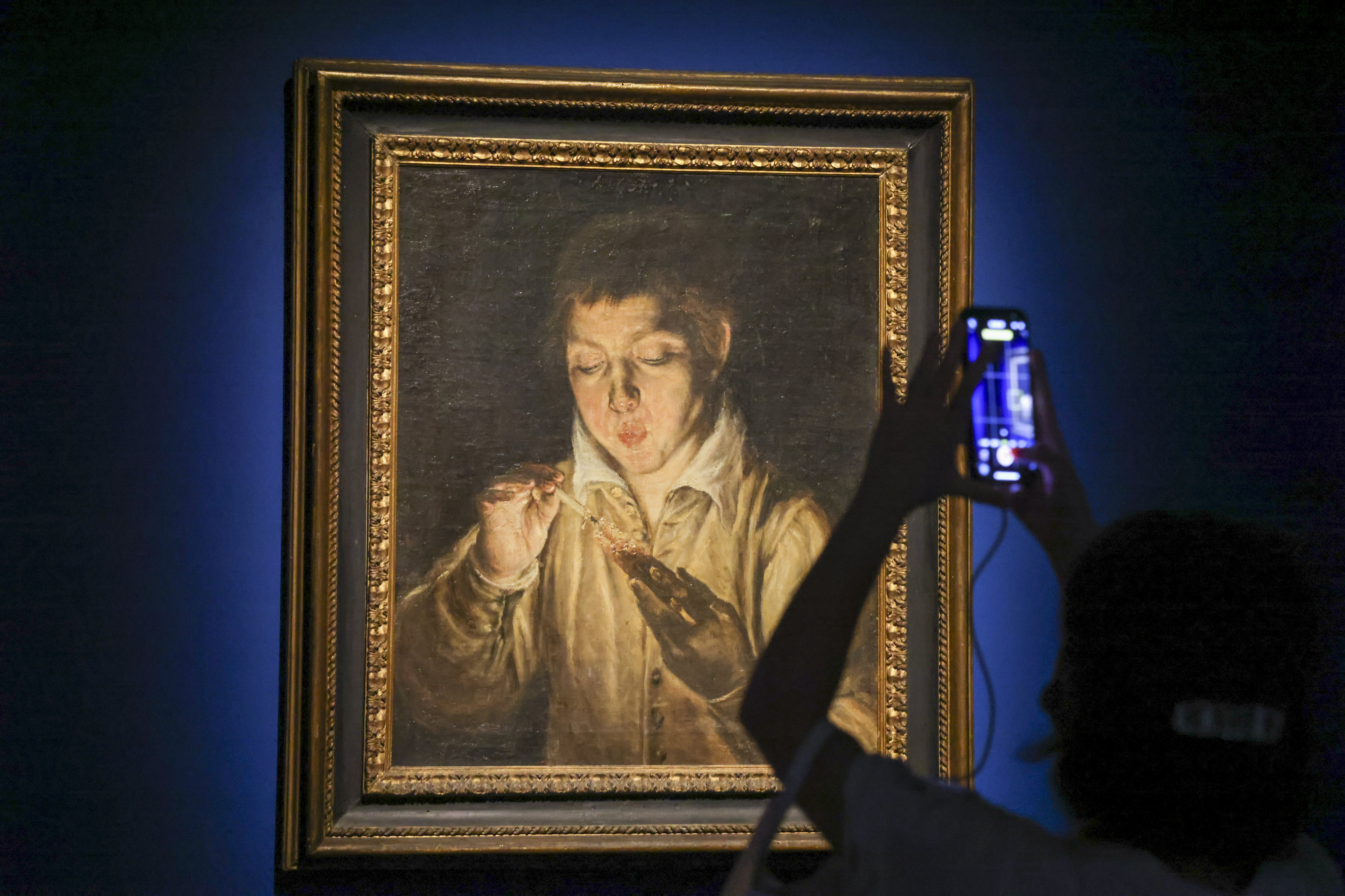 A visitor photographs El Greco’s Boy Blowing on an Ember, showing in “The Road to the Baroque” exhibition at the Hong Kong Museum of Art. Photo:   Nora Tam