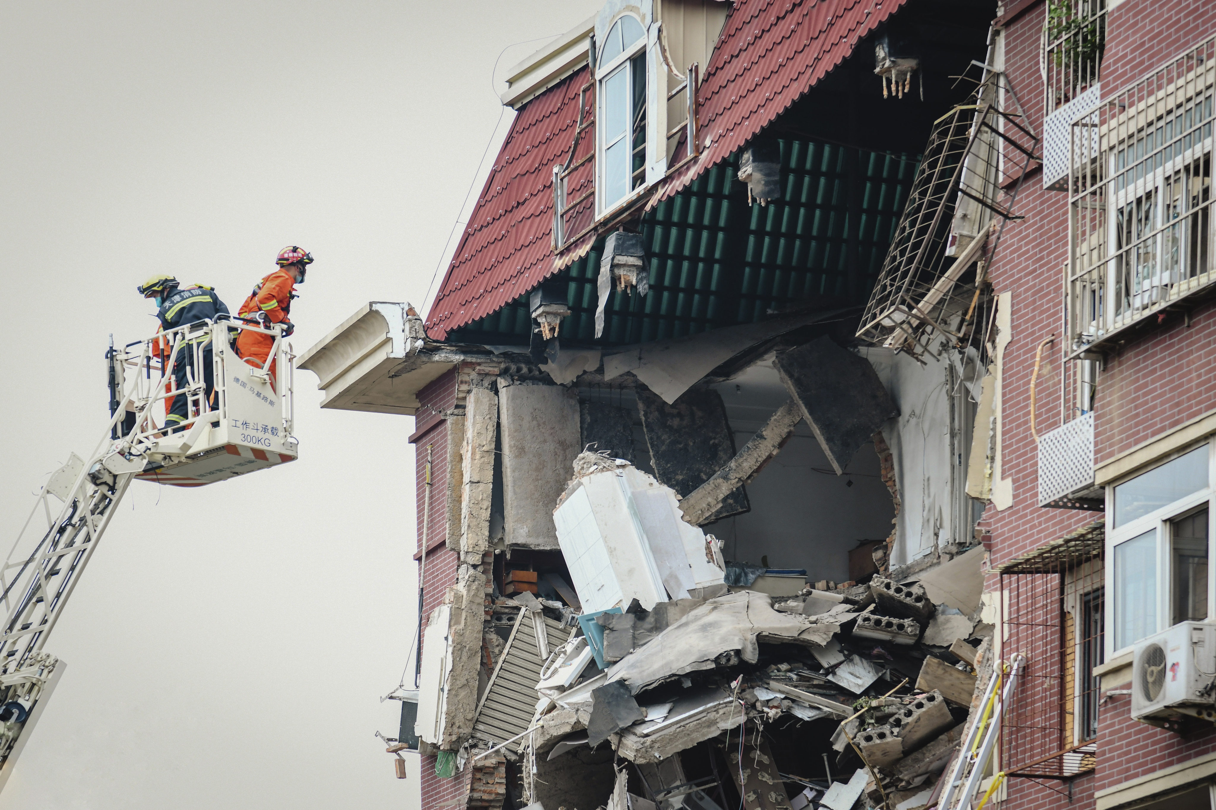 A firefighter looks into the partially collapsed section of a building in Tianjin after an explosion on Tuesday. Photo: Chinatopix via AP