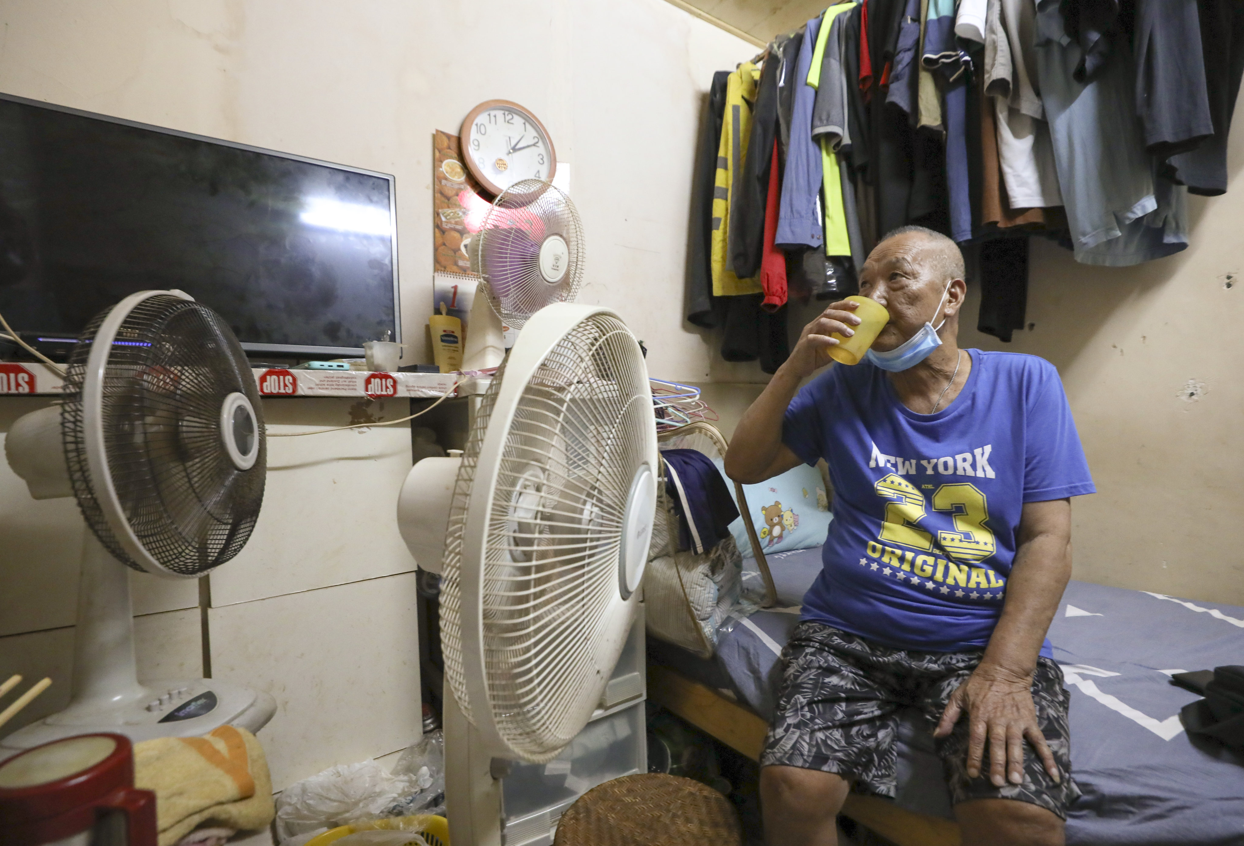 Suen Shau-shing, 78, living in a subdivided unit in Sham Shui Po, uses three fans to try and cool down his flat. Photo: Yik Yeung-man