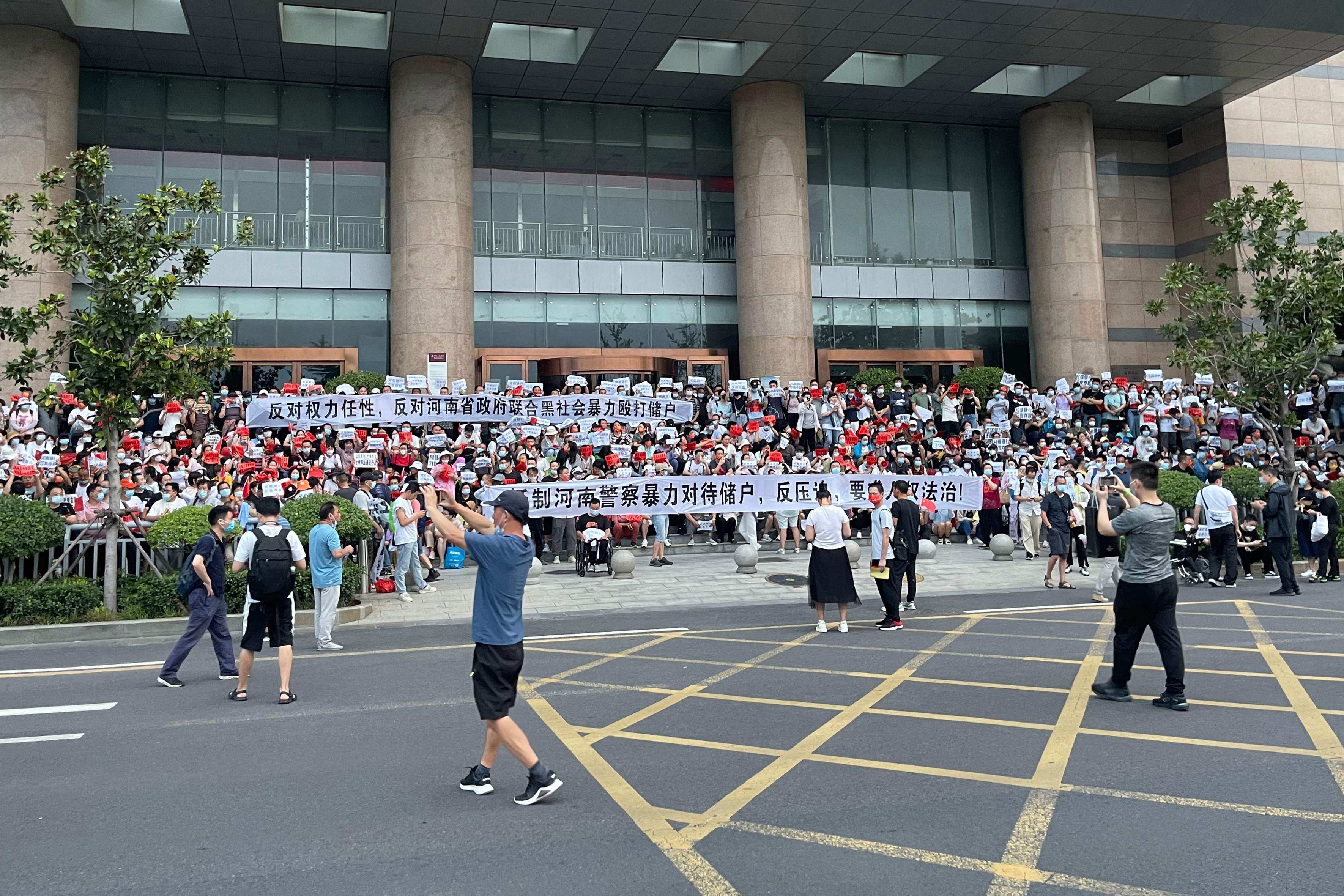 People protest in front of a branch of the People’s Bank of China in Zhengzhou, Henan province, on July 10. Hundreds marched in protest against alleged corruption by local officials in a rare public demonstration. Photo: AFP