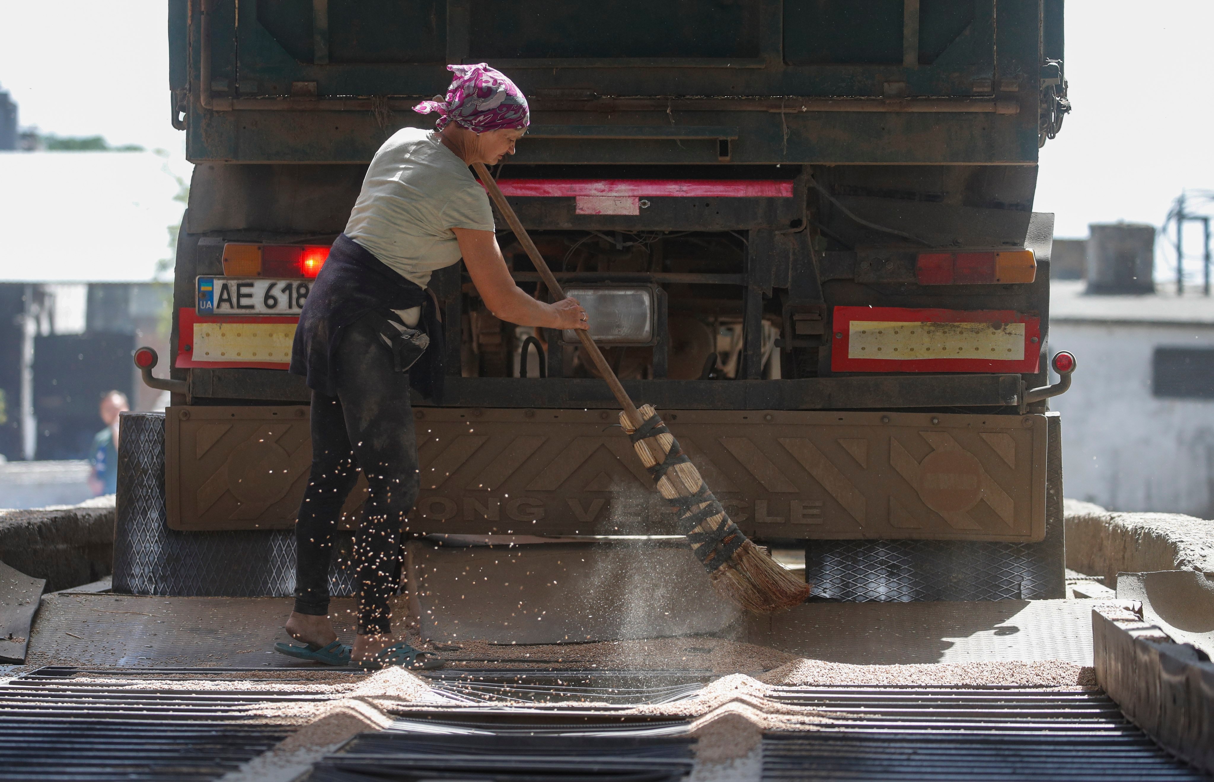 A woman finishes unloading wheat from a truck at a grain storage facility in Ukraine’s southeastern Zaporizhia region on July 14. Photo: EPA-EFE