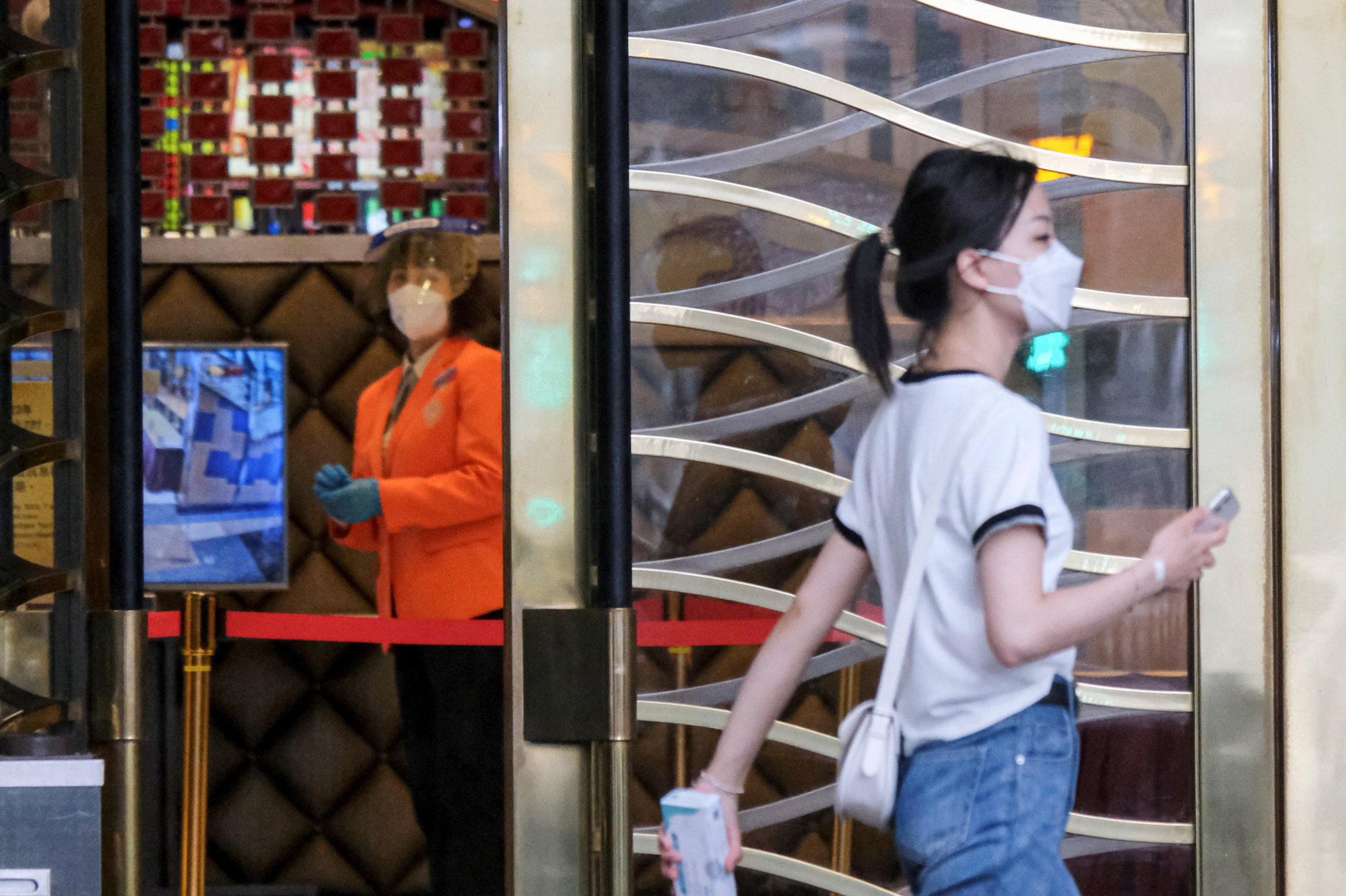A woman walks past a staff member inside the Grand Lisboa casino amid the Covid-19 outbreak in Macau on July 4, 2022. Photo: Reuters