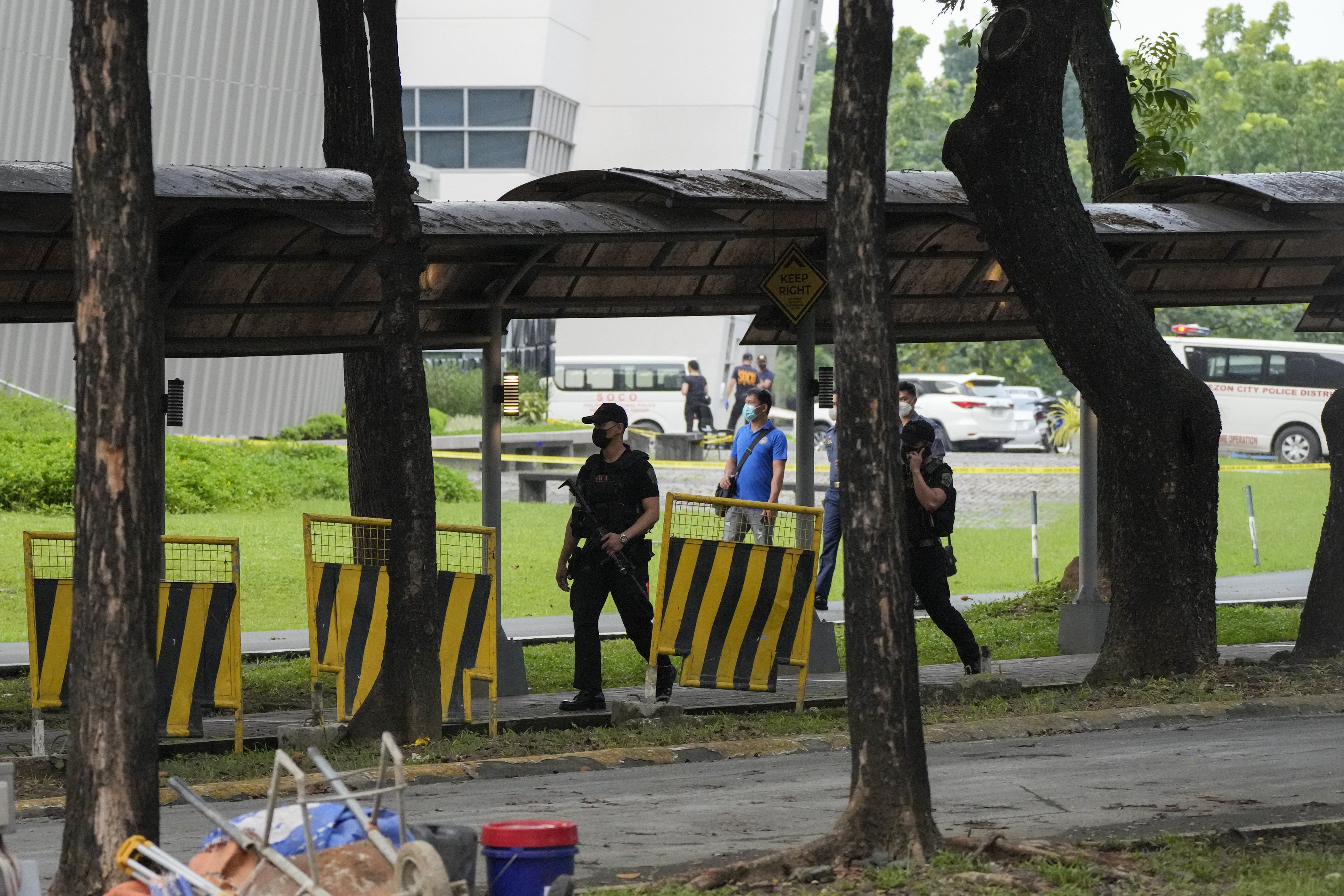 Armed police walk inside the Ateneo de Manila University campus in Quezon city, Philippines, where a gunman killed at least three people. Photo: AP