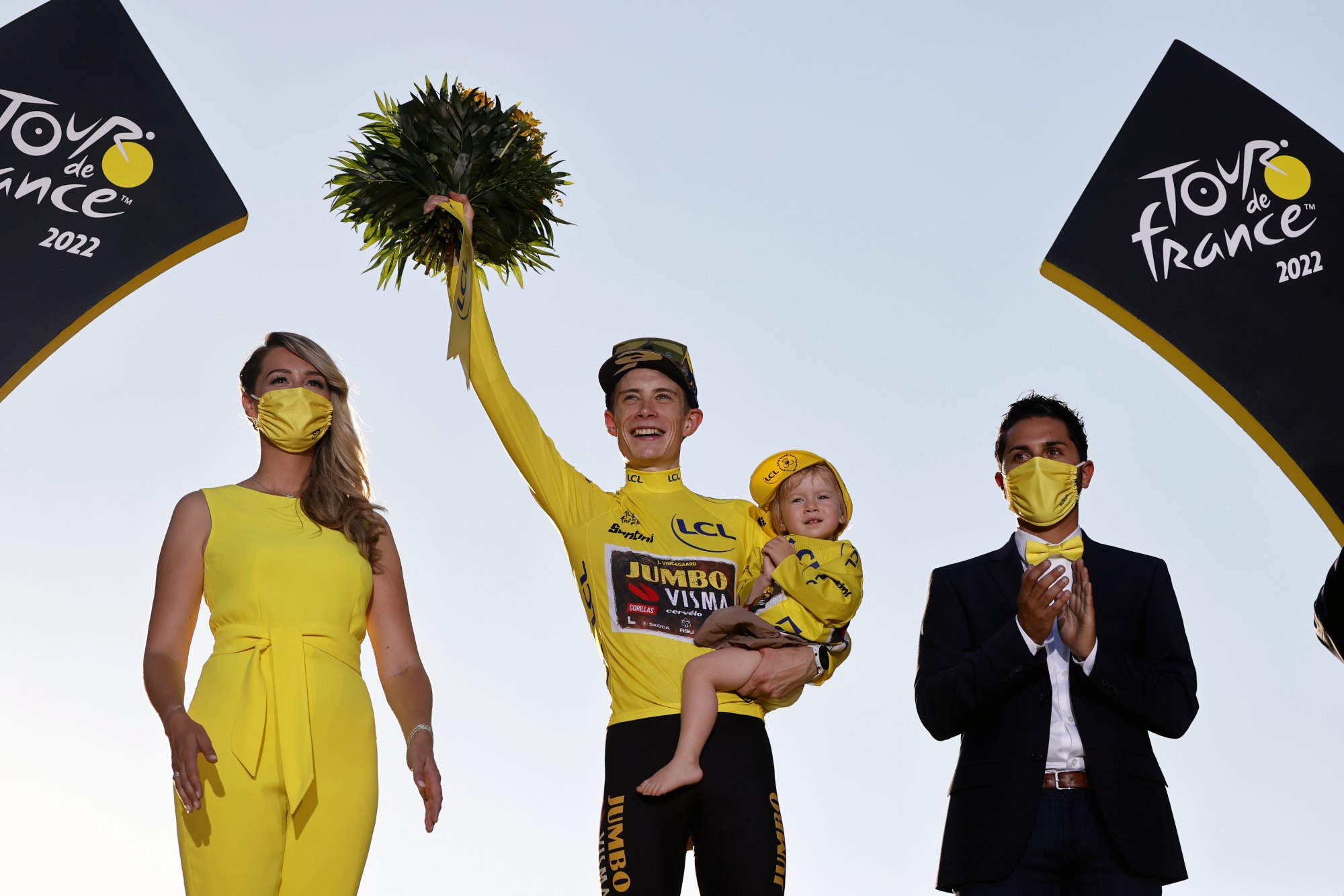 Jonas Vingegaard of Jumbo Visma carries his daughter Frida as he celebrates on the podium with the overall leader’s yellow jersey. Photo: EPA-EFE