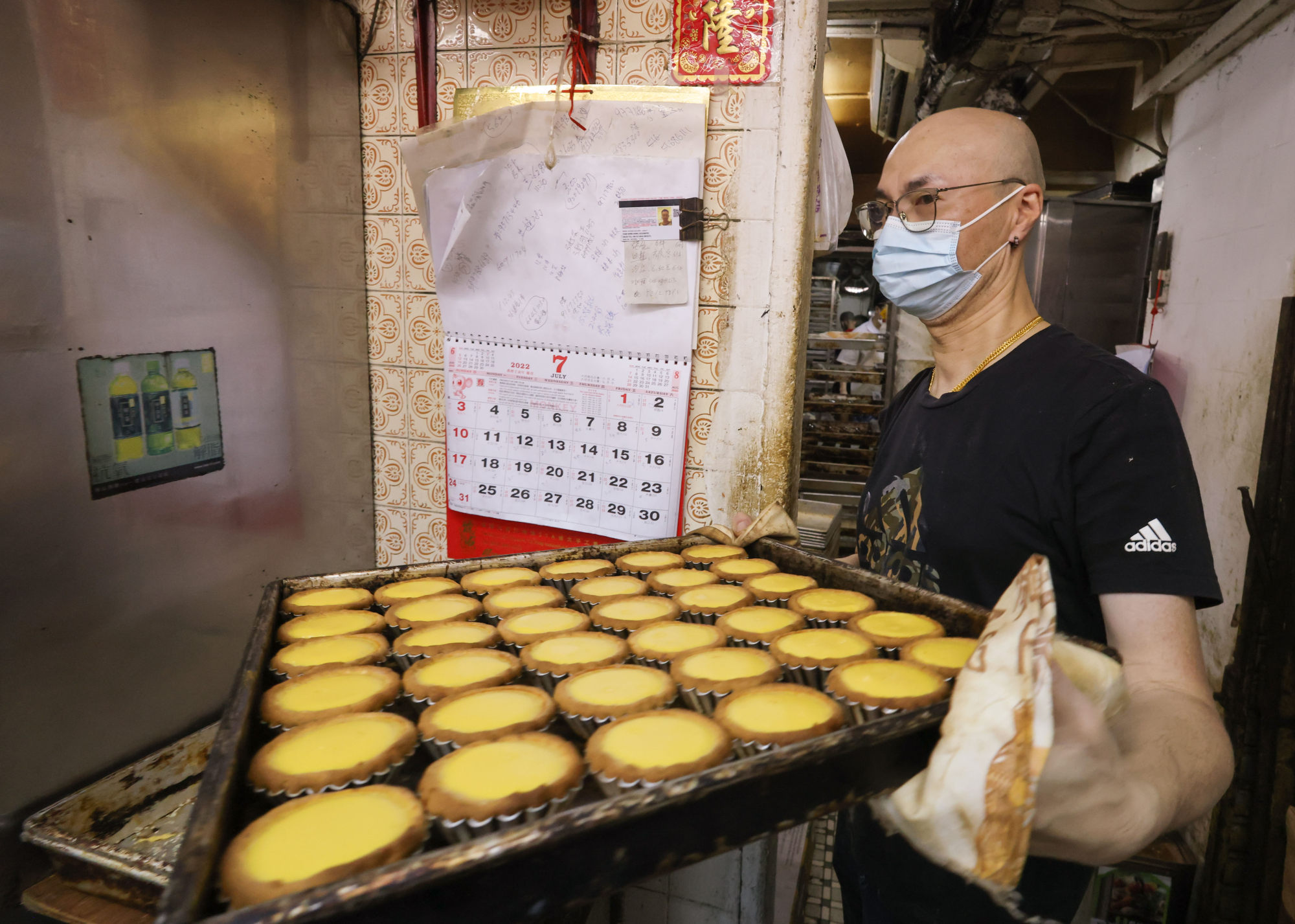 A staff member serves up egg tarts fresh from the oven. Photo: Dickson Lee