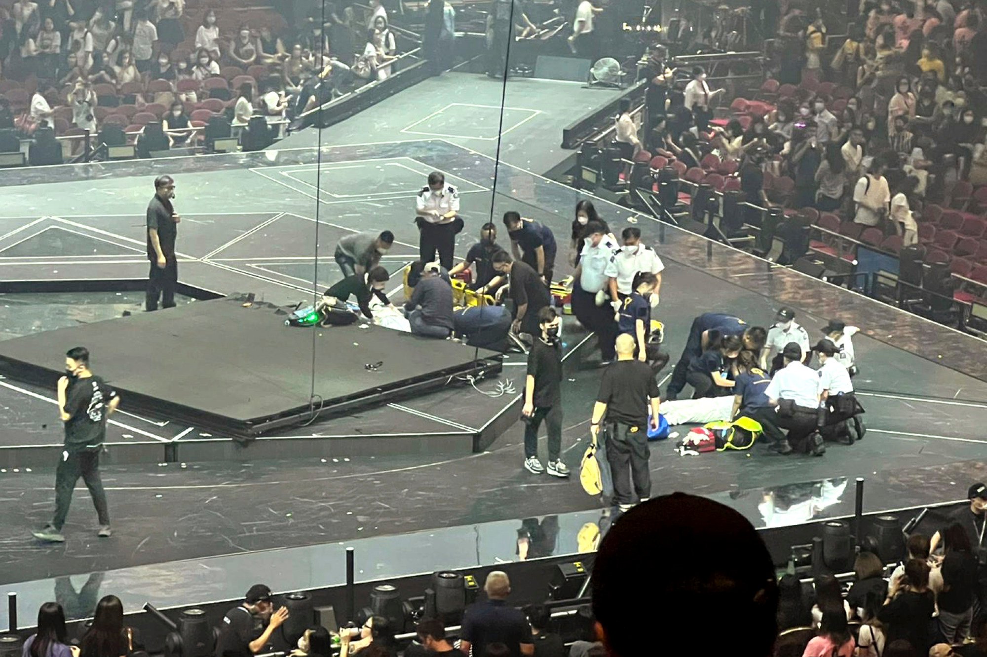 Emergency crew tend to the injured on stage as anxious audience members look on. Photo: AP