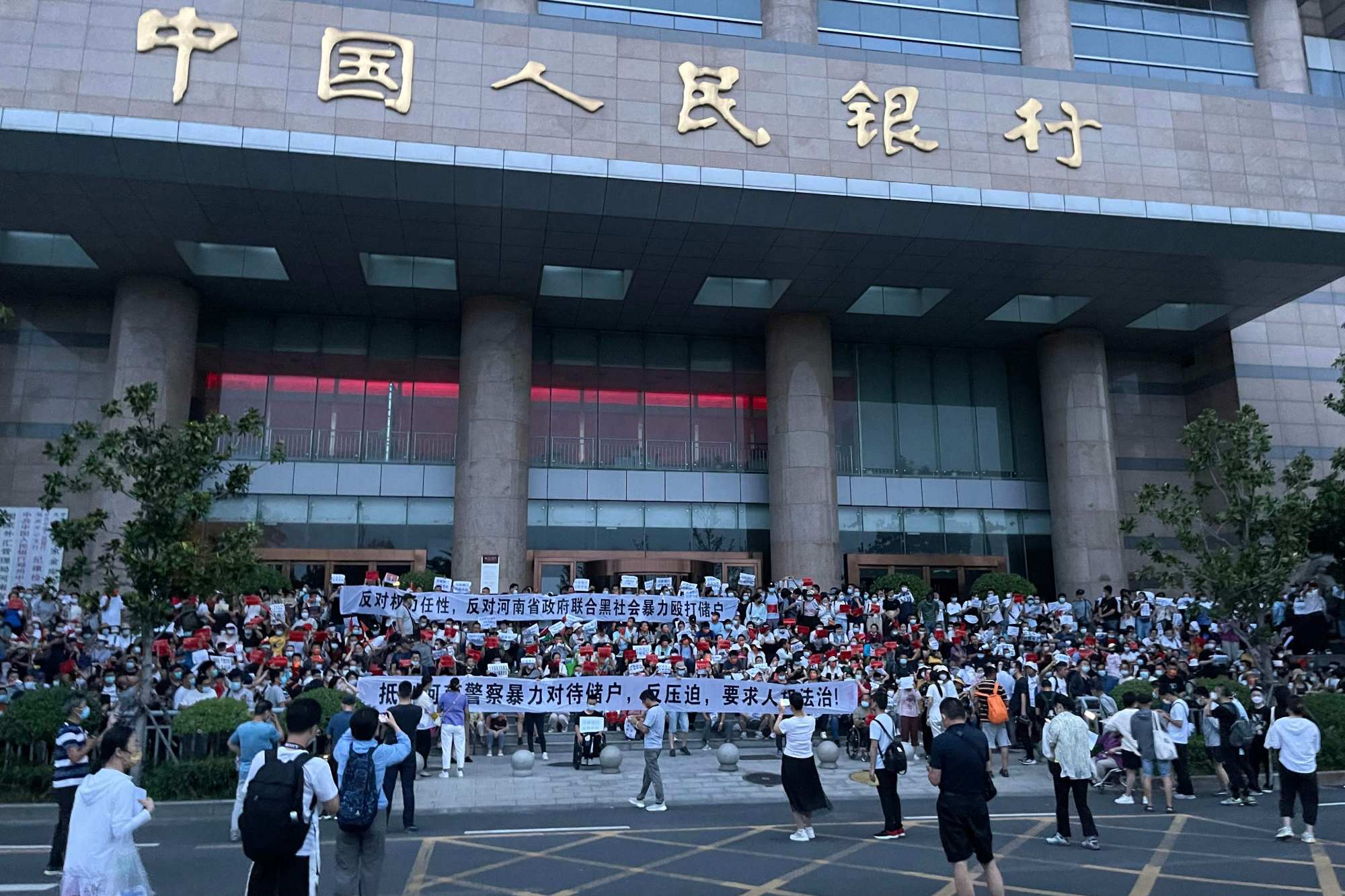 Depositors staged a protest rally outside the Zhengzhou branch of the People’s Bank of China in Henan province on July 10 after a syndicate absconded with hundred of millions of yuan of bank deposits. Photo: Handout via Agence France-Presse.