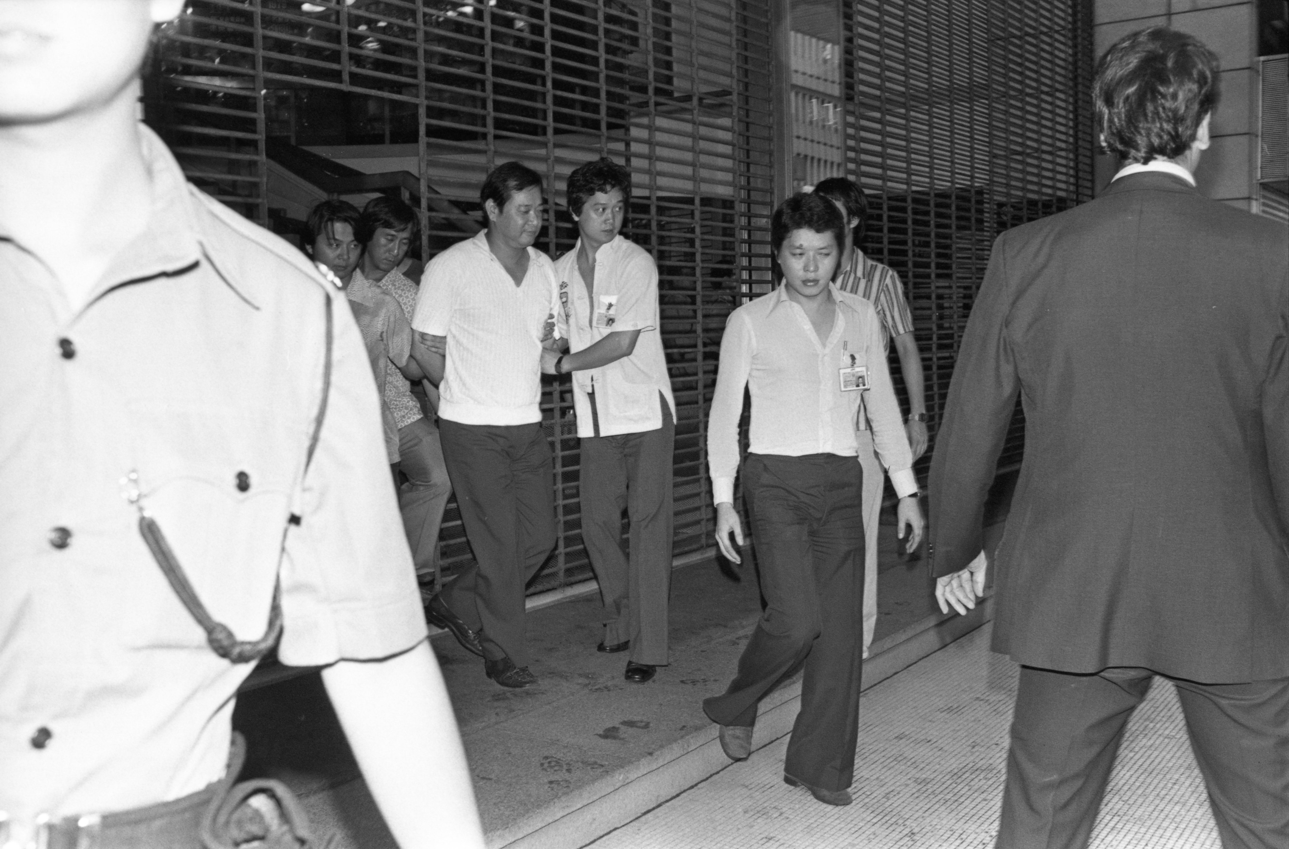 In 1979, a lone gunman in Hong Kong shot a property developer and terrorised four women hostages for five hours before he was talked into surrendering, handcuffed and taken away (above) by police. Photo: SCMP