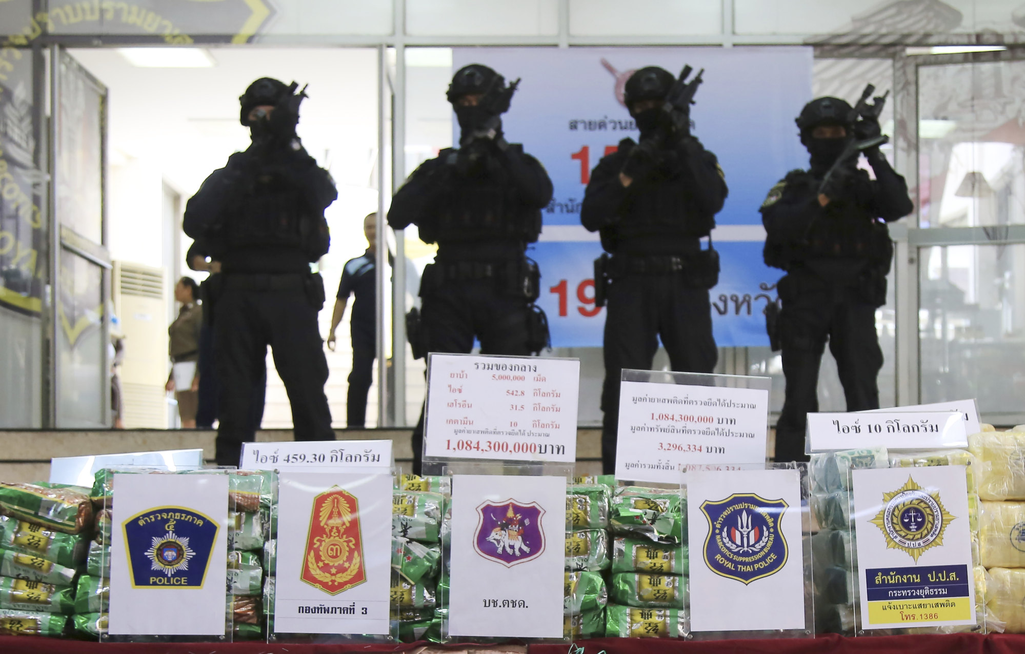 Thai policemen stand in front of seized packages of methamphetamines on display at the Narcotics Suppression Bureau in Bangkok on July 15, 2019. Photo: AP