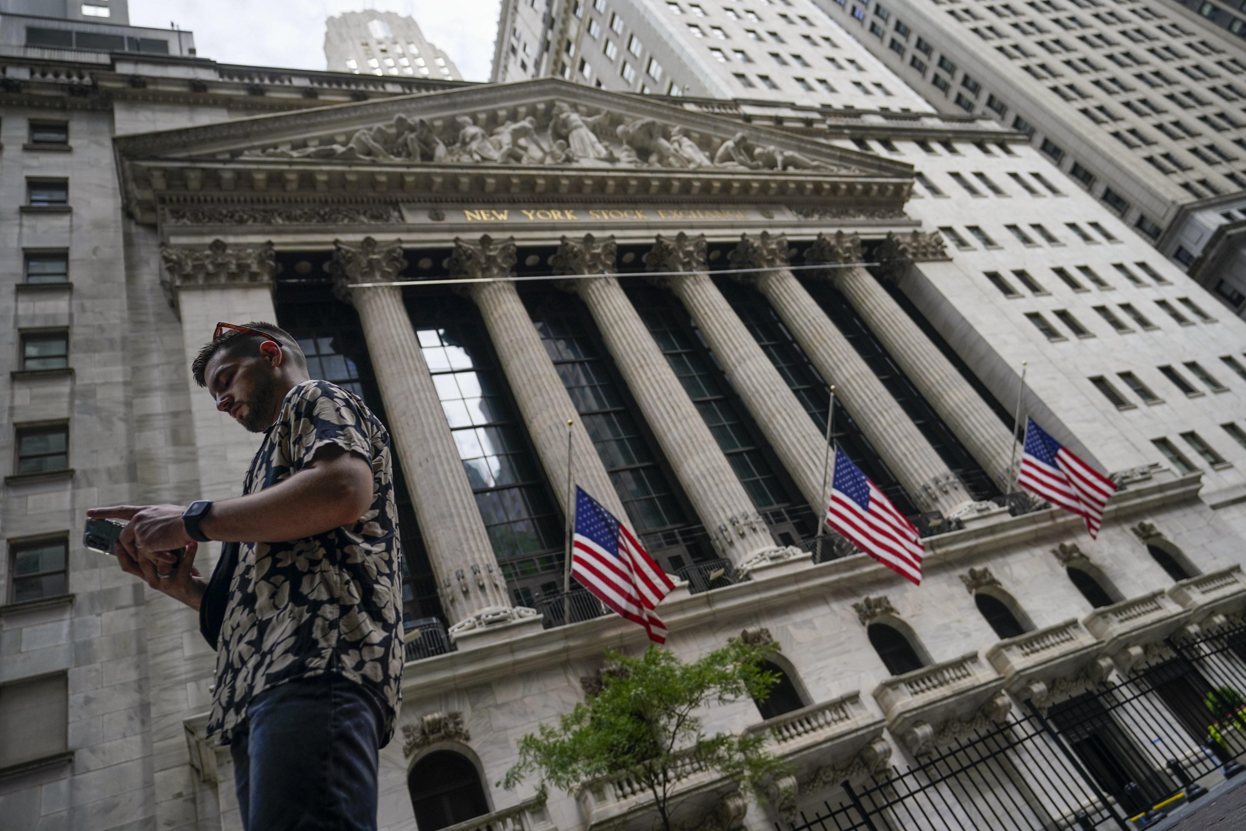 A man walks past the New York Stock Exchange on July 8. Even as the US acknowledged a technical recession and the IMF warned of “gloomy” global economic prospects in July, global equities were staging a comeback. Photo: AP 