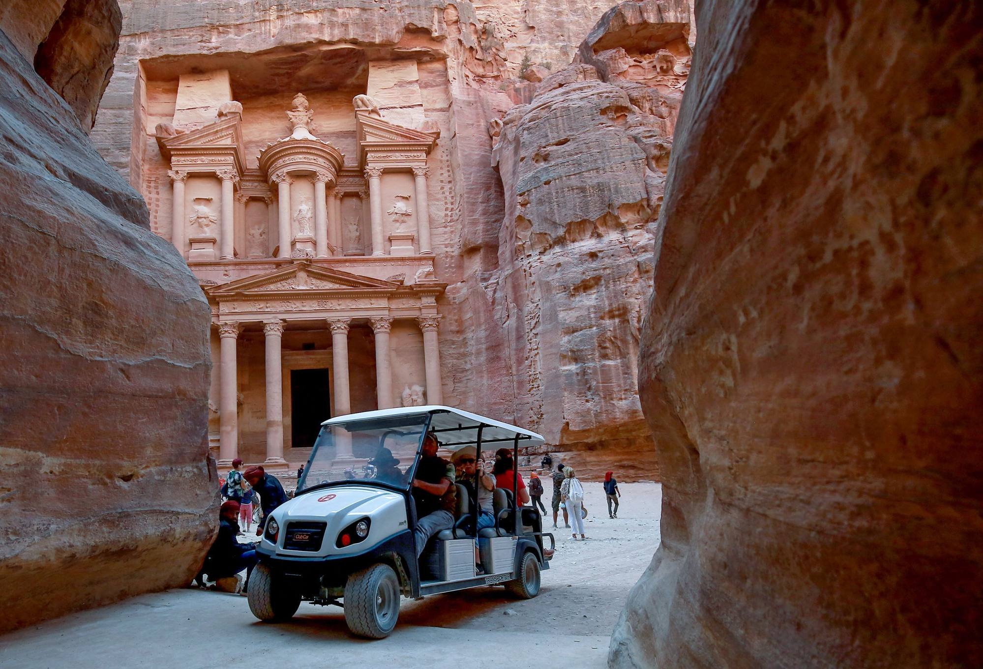 Tourists ride an electric cart, during their trip to Jordan’s famed ancient city of Petra, some 230km south of the capital Amman. Photo: AFP