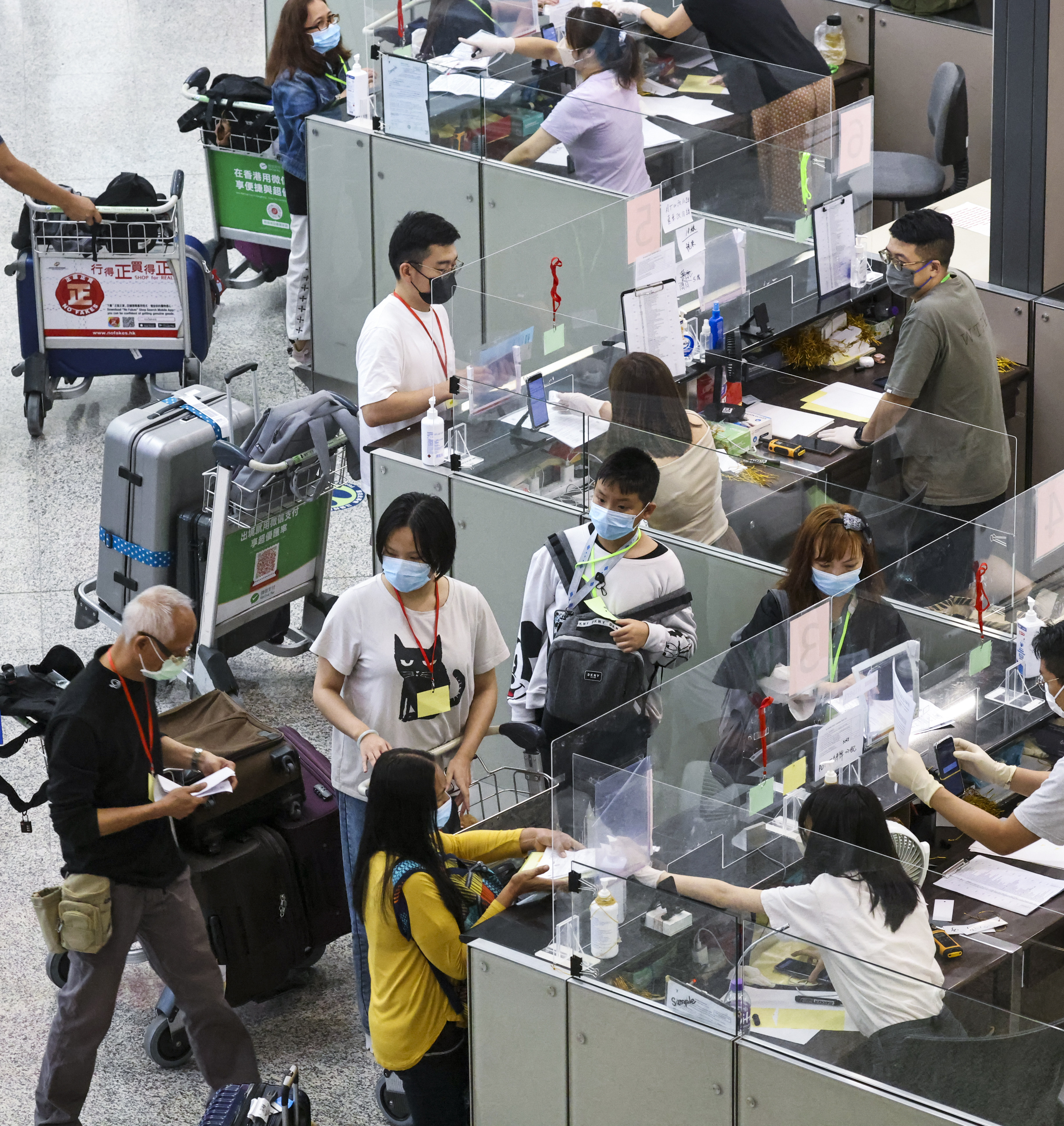 Travellers arrive at Hong Kong airport check in for transport to quarantine hotels. Photo: K. Y. Cheng
