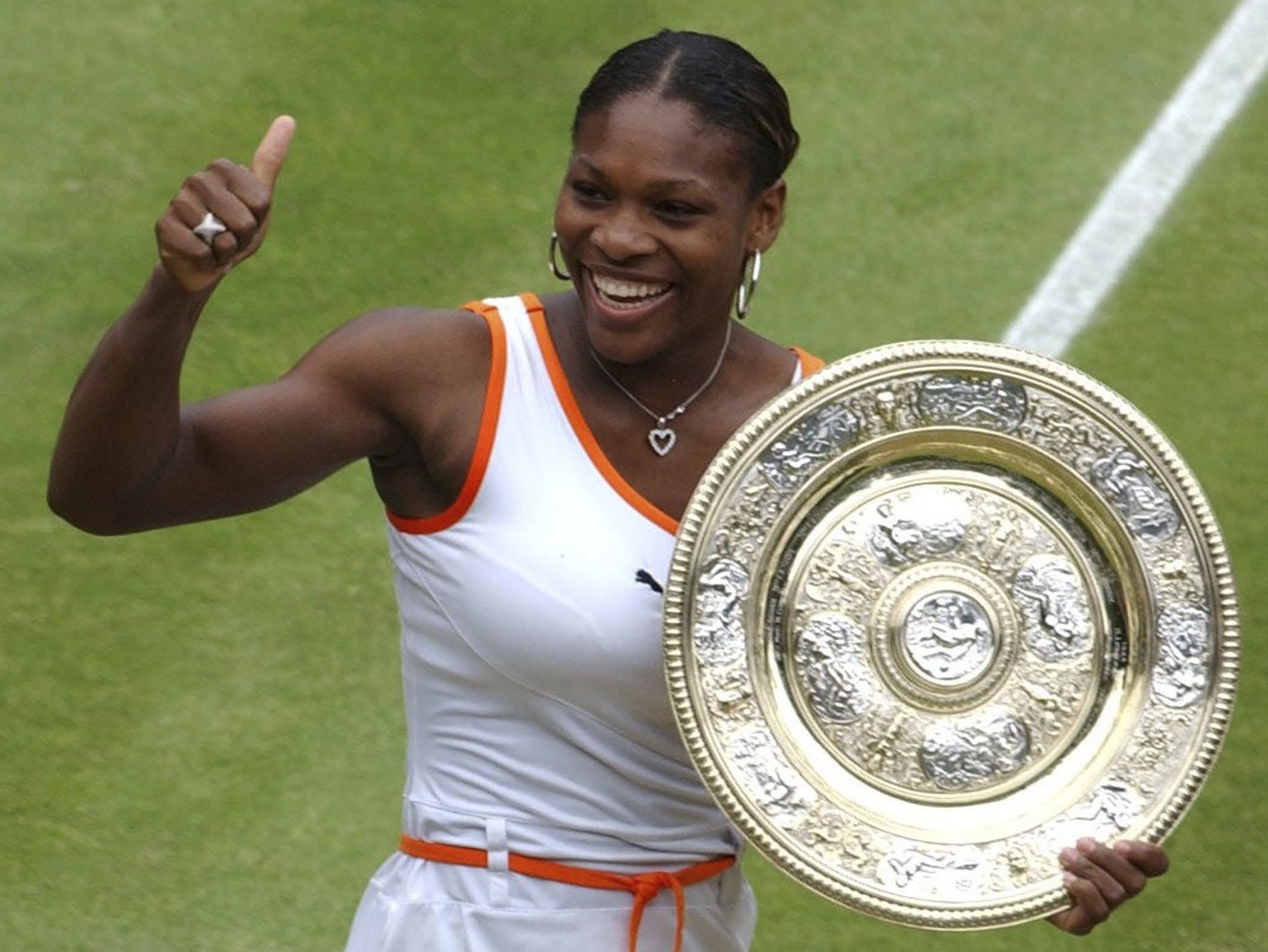 Serena Williams gives a thumbs up as she holds her trophy after defeating her sister Venus in the women’s singles final on the Centre Court at the All England Lawn Tennis Championships at Wimbledon, in 2003. Photo: AP Photo