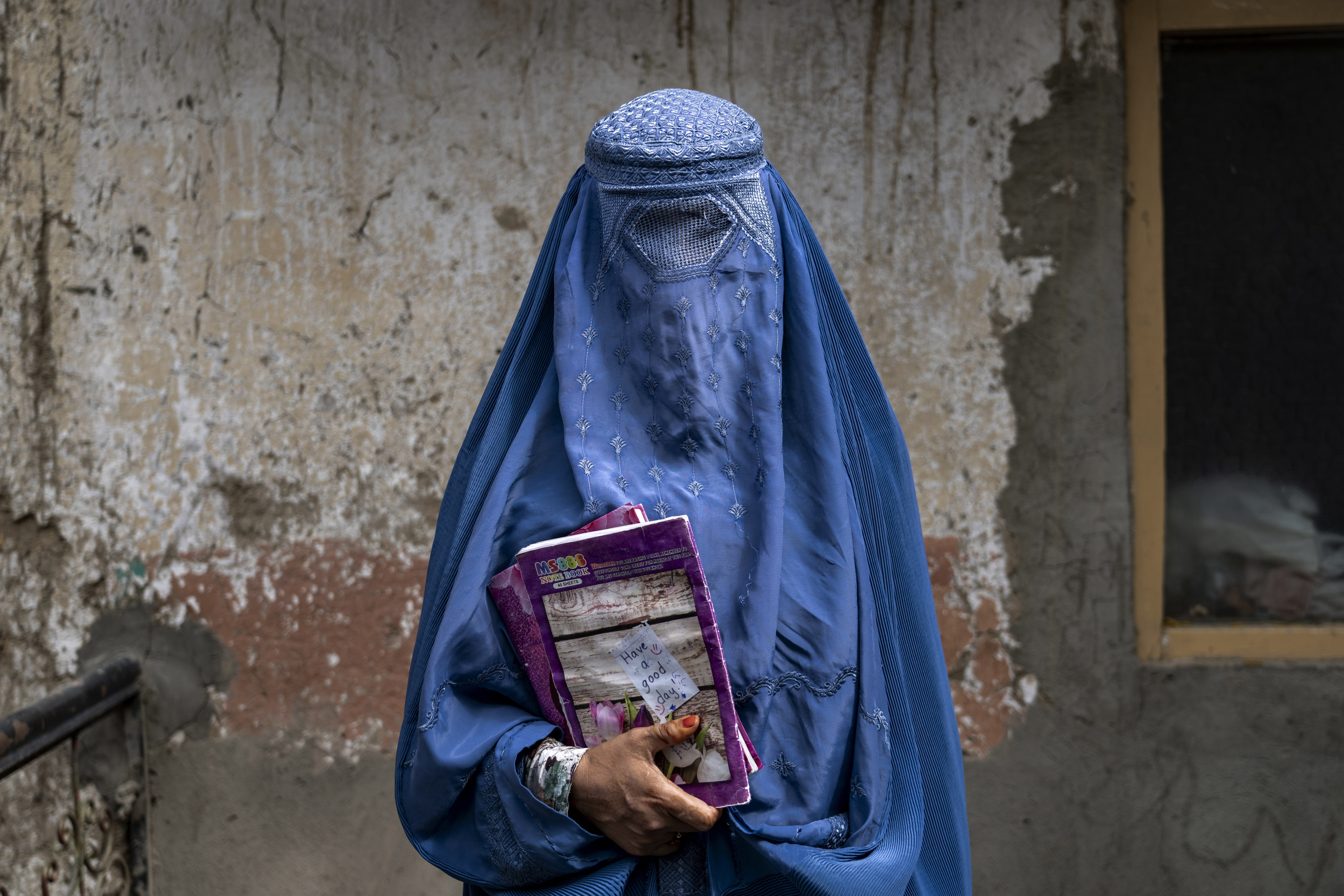 An Afghan woman leaves an underground school which she attends with her daughter, in Kabul, Afghanistan, on July 30. Photo: AP 