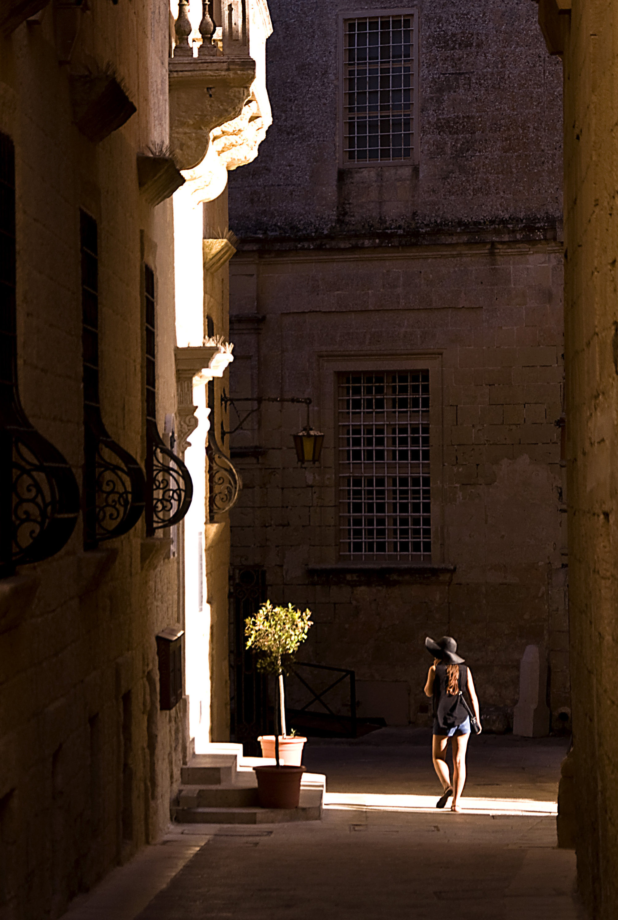 Oblique shafts of sunlight illuminate a narrow lane in the old town of Mdina in Malta. Photo: Tim Pile