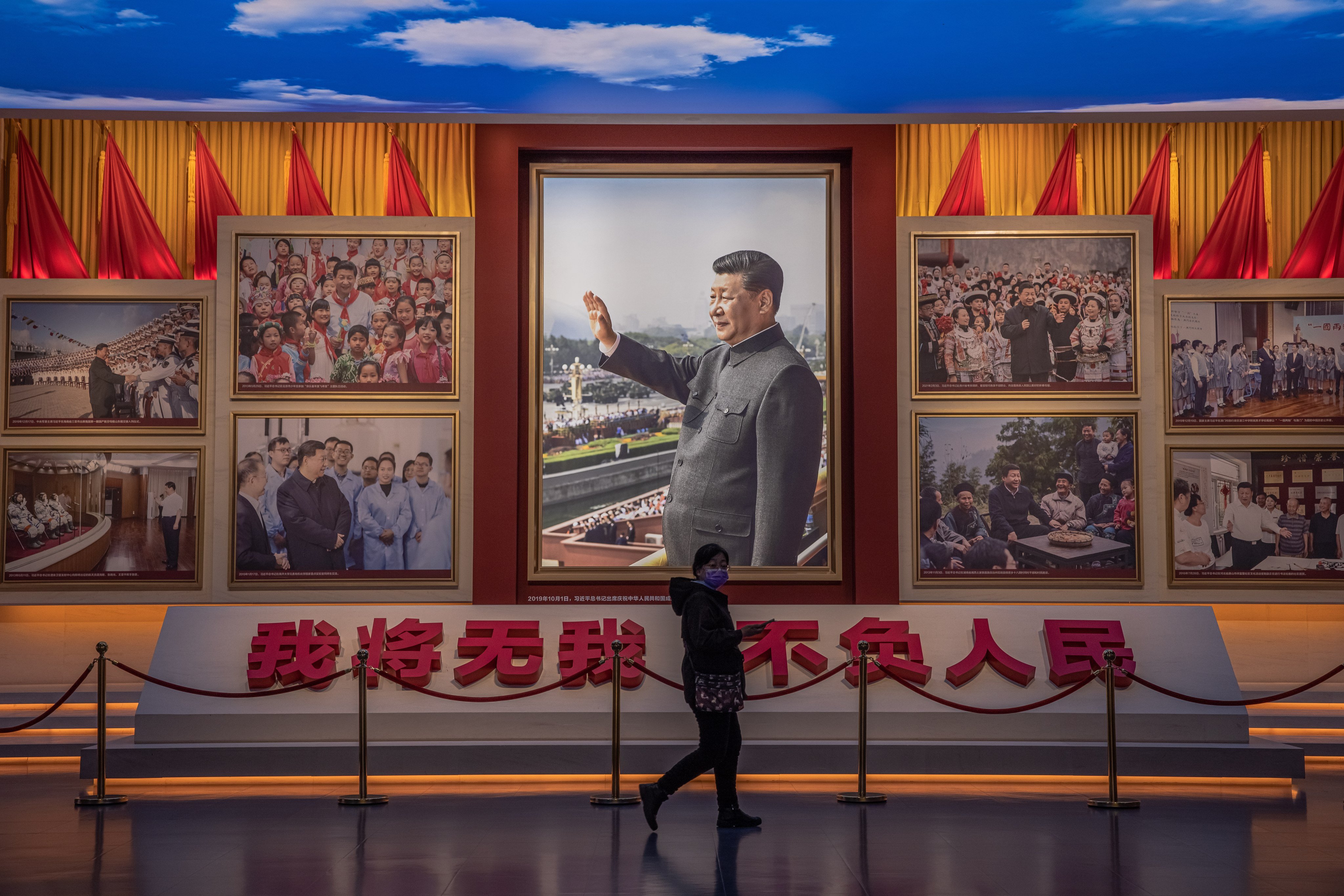 A visitor walks in front of pictures of President Xi Jinping at the Museum of the Communist Party in Beijing. Photo: EPA-EFE