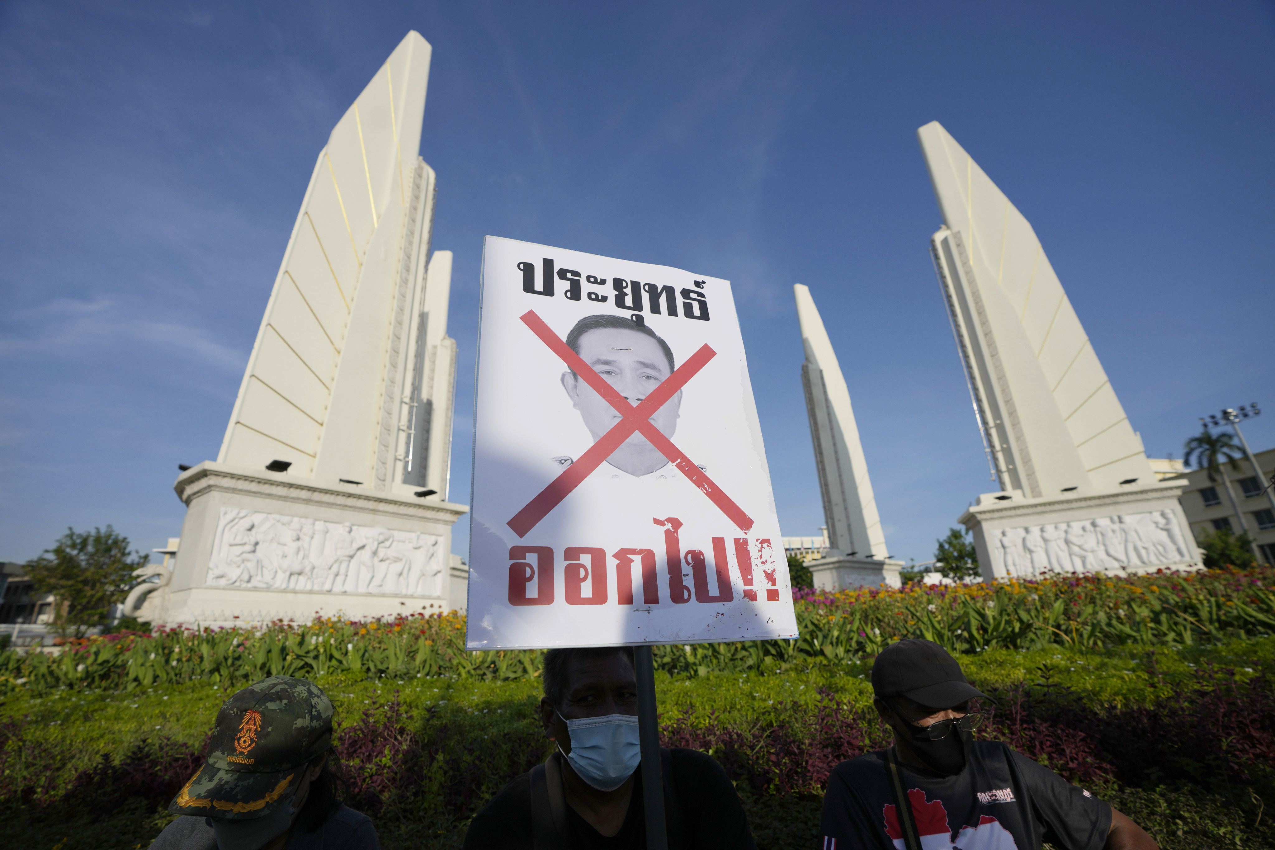 Anti-government protesters with a poster that reads “Prayuth get out” in Bangkok. Photo: AP