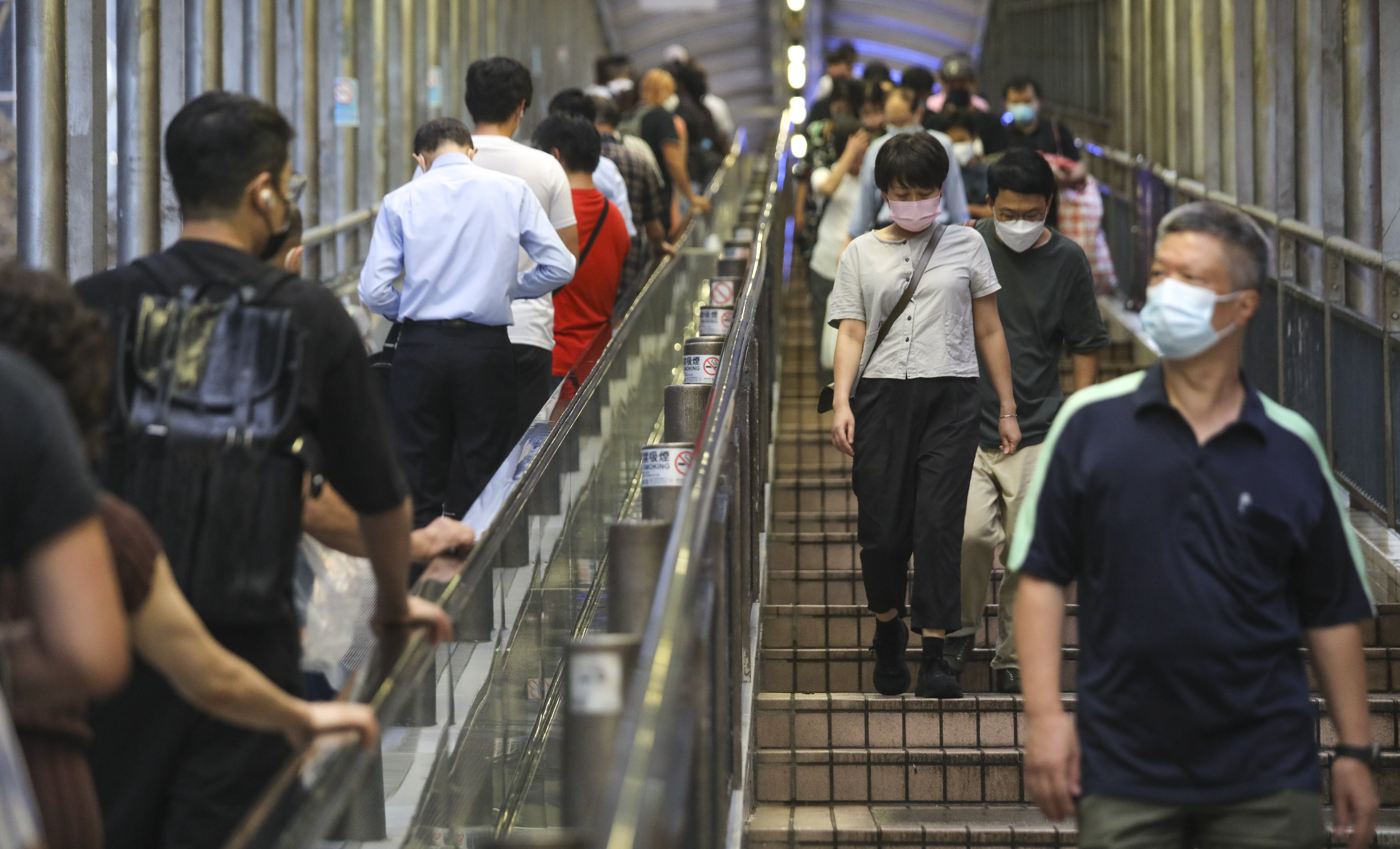 People in face masks walk on the Mid-Levels escalator in Central. Uncertainties surrounding Covid-19, ongoing geopolitical risks, restrictions on travel, rising inflationary pressure and interest rate hikes have combined to interrupt the global economy, Sino Group owner Robert Ng Chee Siong says. Photo: Xiaomei Chen