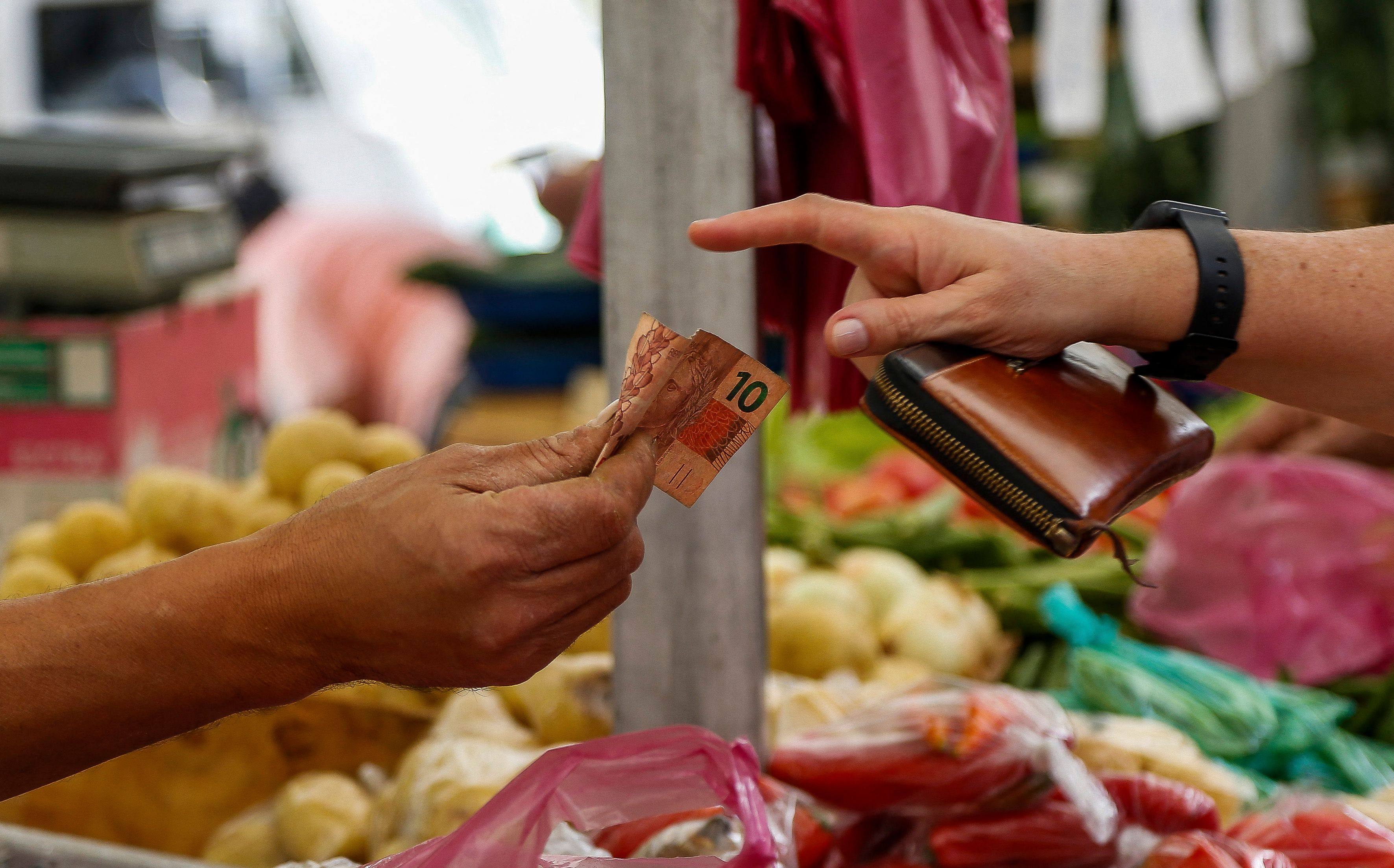 A customer pays in cash at a vegetables stall at a street market in Sao Paulo, Brazil, on August 25. Shocks to the global system resulting from pandemic-induced supply interruptions followed by the Ukraine war could persist for years rather than months. Photo: AFP