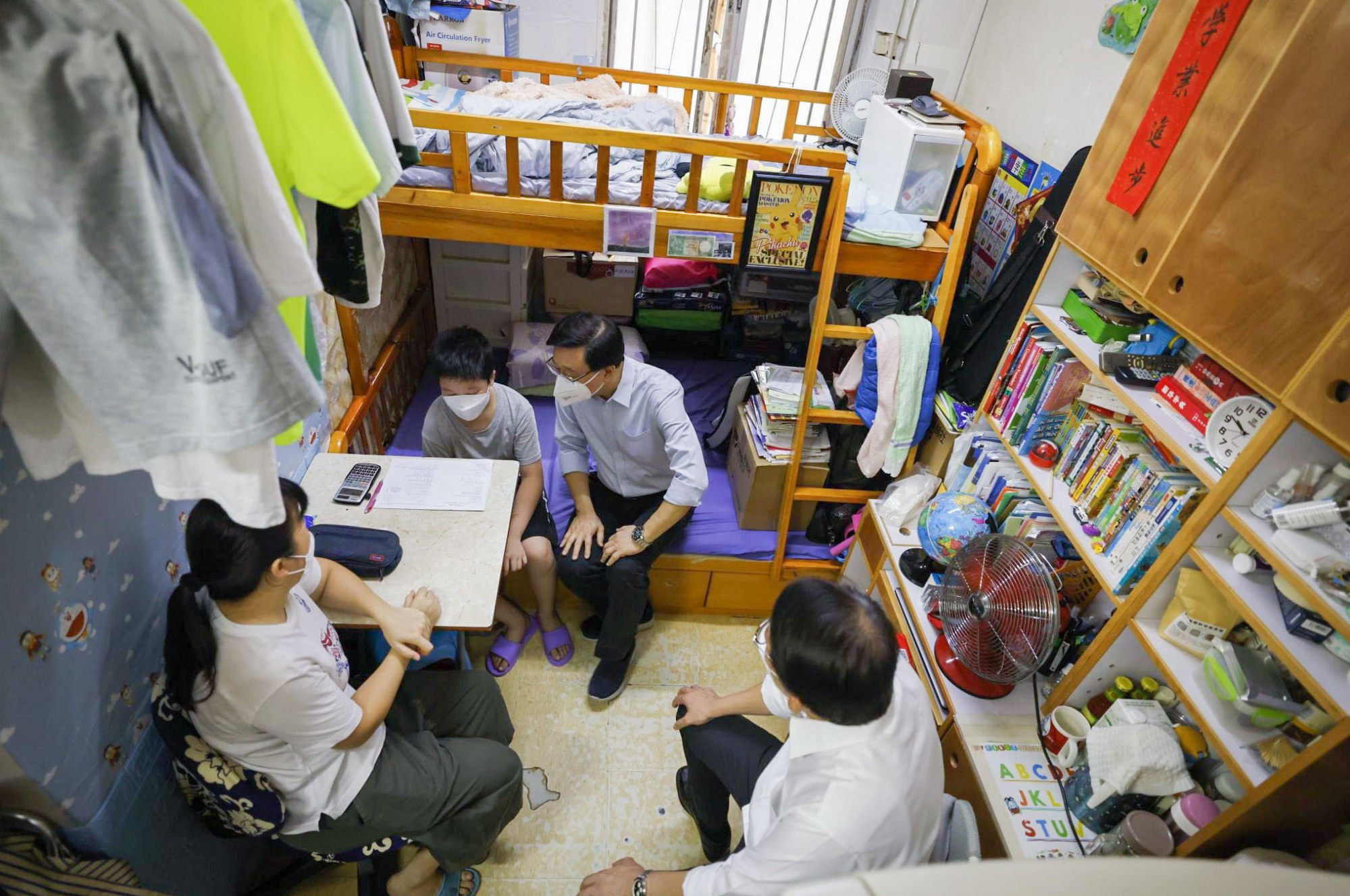 Chief Executive John Lee visits residents of a subdivided flat in Sham Shui Po in July. Photo: Facebook