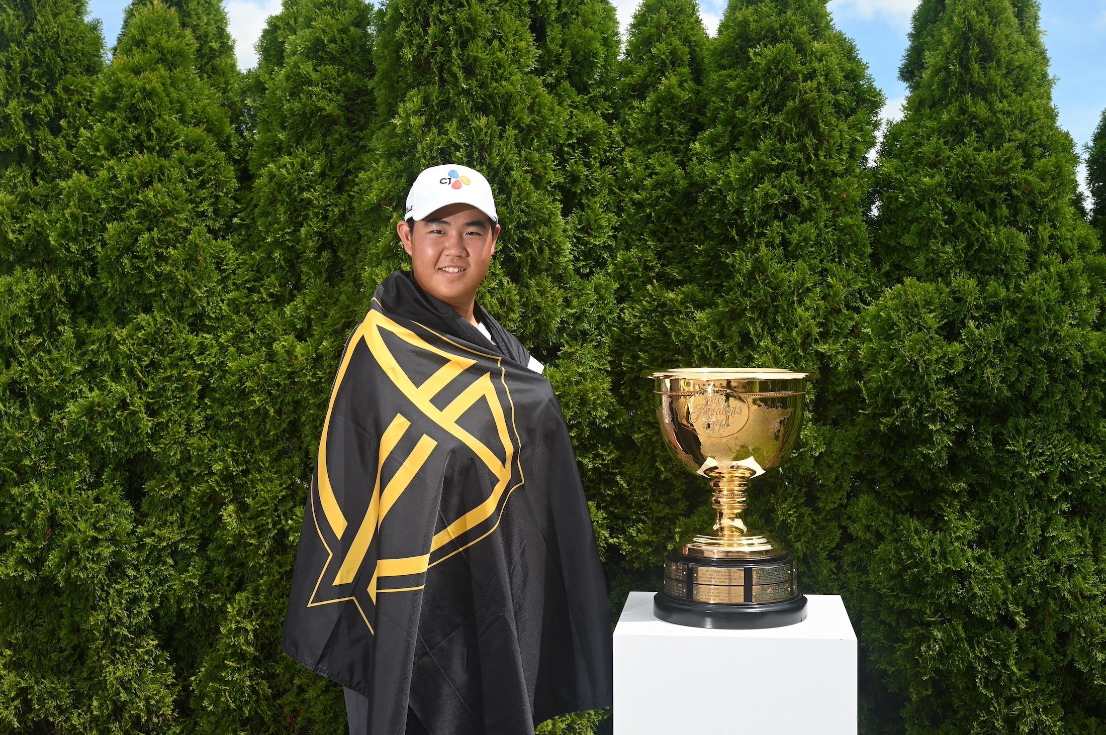 Joohyung Kim with the International Team flag and Presidents Cup. Photo: PGA Tour