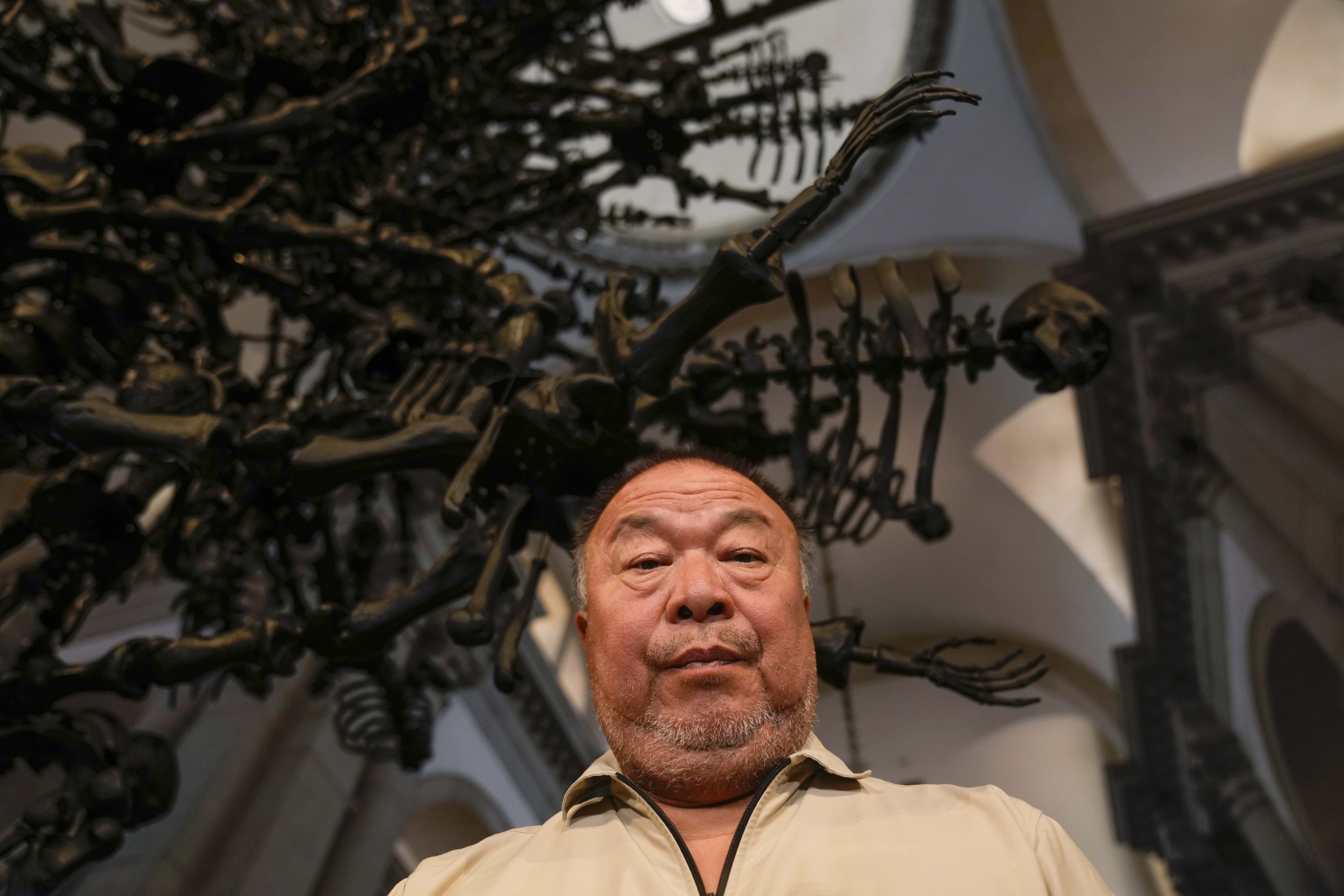Chinese artist Ai Weiwei poses in front of his glass sculpture La Commedia Umana at the San Giorgio deconsecrated church in Venice, Italy on Friday. Photo: AP 