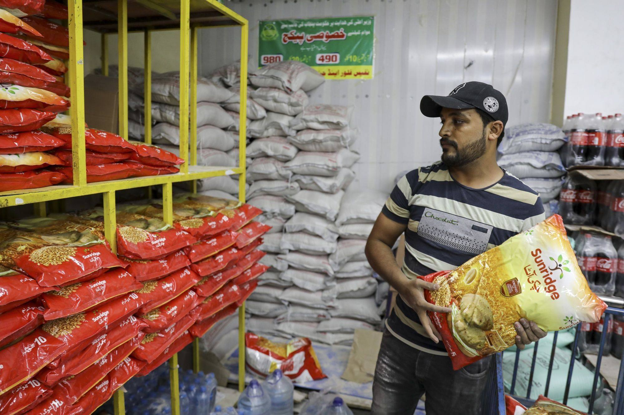 A worker arranges sacks of wheat flour at a supermarket in Islamabad. Pakistan is moving to secure wheat and vegetable supplies after the floods. Photo: Bloomberg