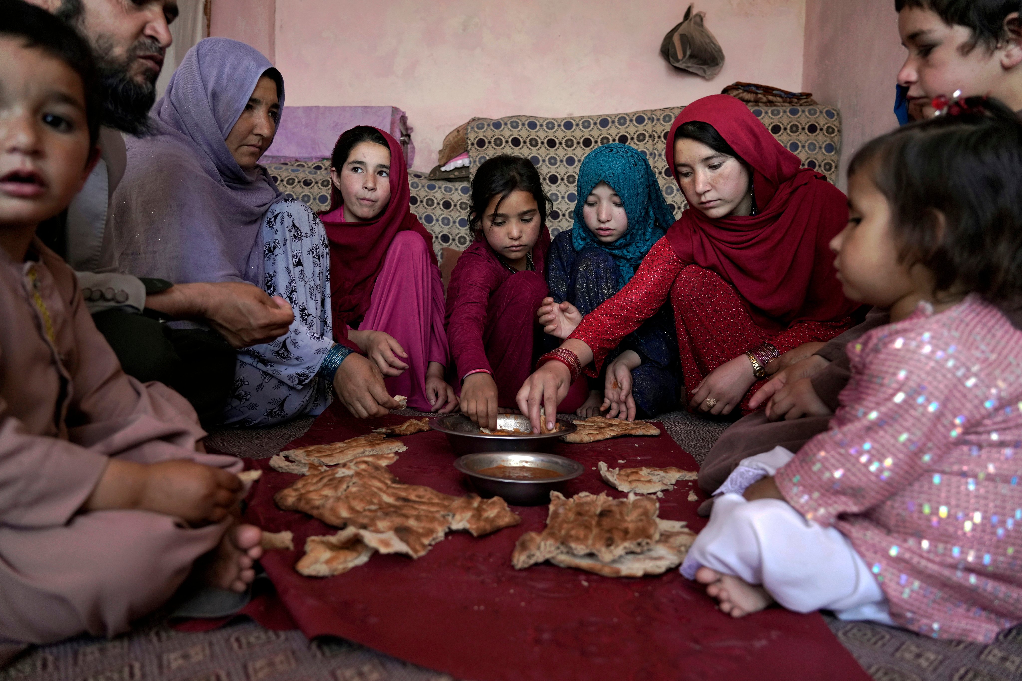 A family eats lunch at home in one of the poor neighbourhoods in Kabul, Afghanistan, on May 21. UN humanitarian chief Martin Griffiths has said that Afghanistan faces deepening poverty, with millions at risk of famine. Photo: AP