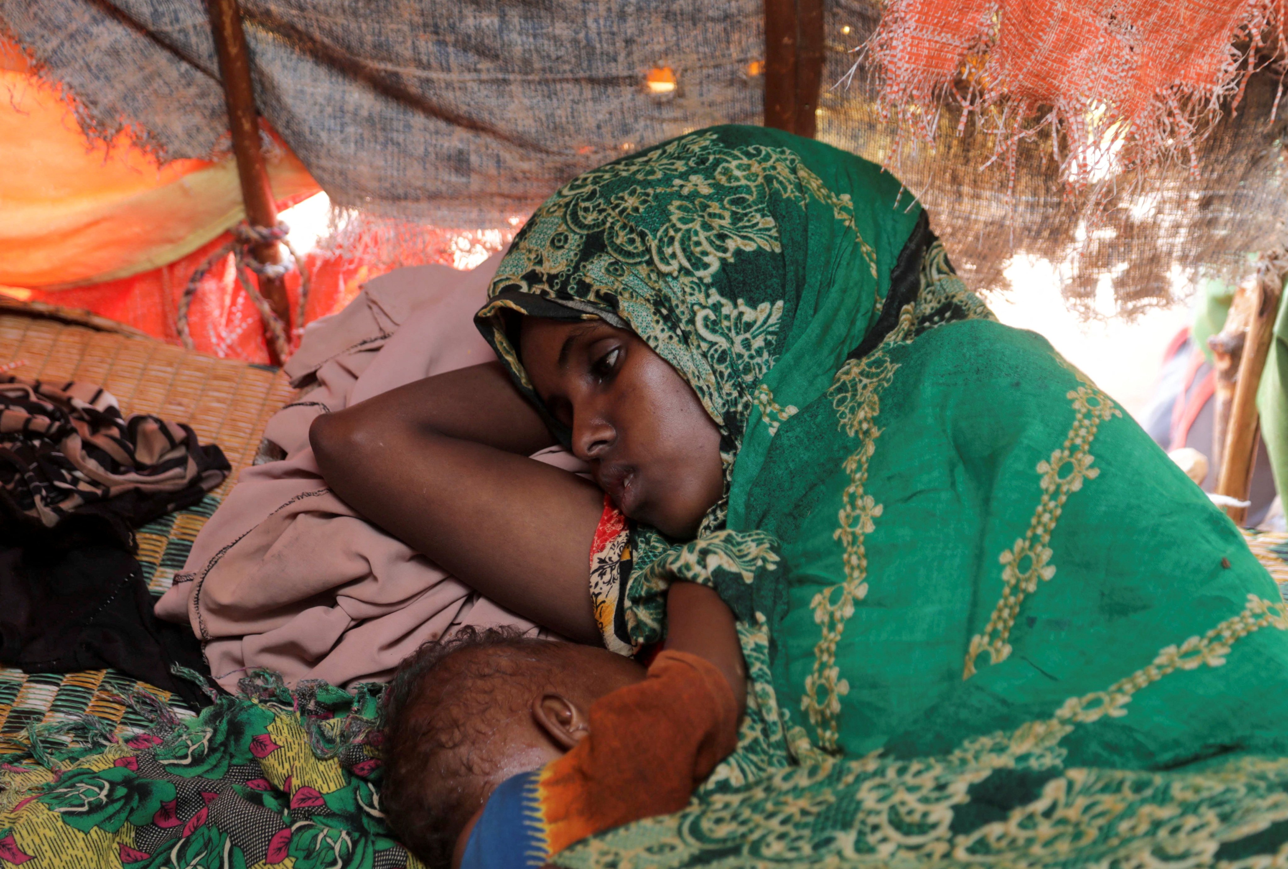 Abdia Aden Mohamed rests with her eight-month-old baby inside a makeshift shelter at a camp for internally displaced people in Somalia. File photo: Reuters