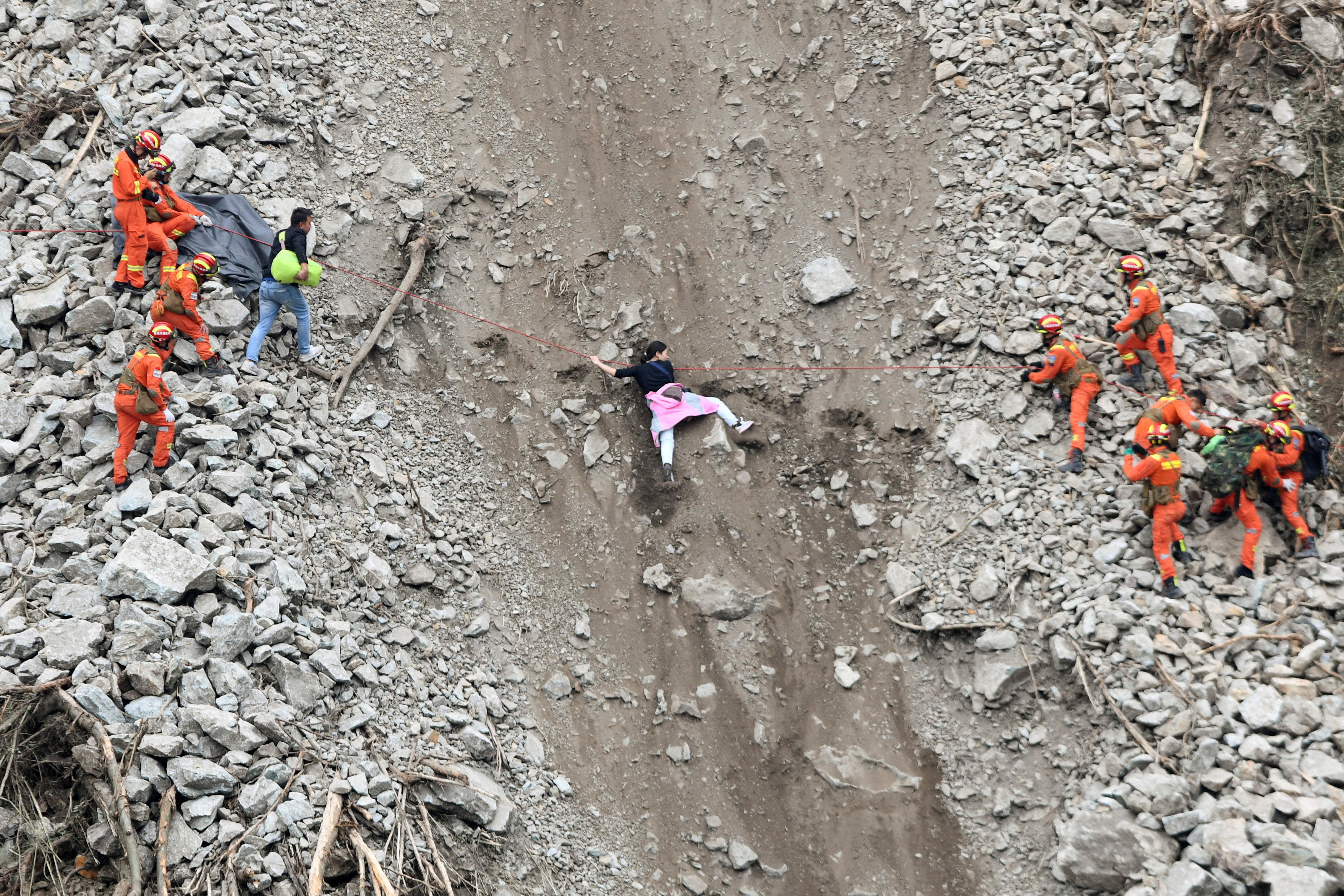 Rescue workers evacuate quake-affected residents at the site of a landslide following a 6.8-magnitude earthquake in Sichuan province, September 6. As the death toll climbed, authorities imposed strict entry requirements to the disaster zone. Photo: Reuters