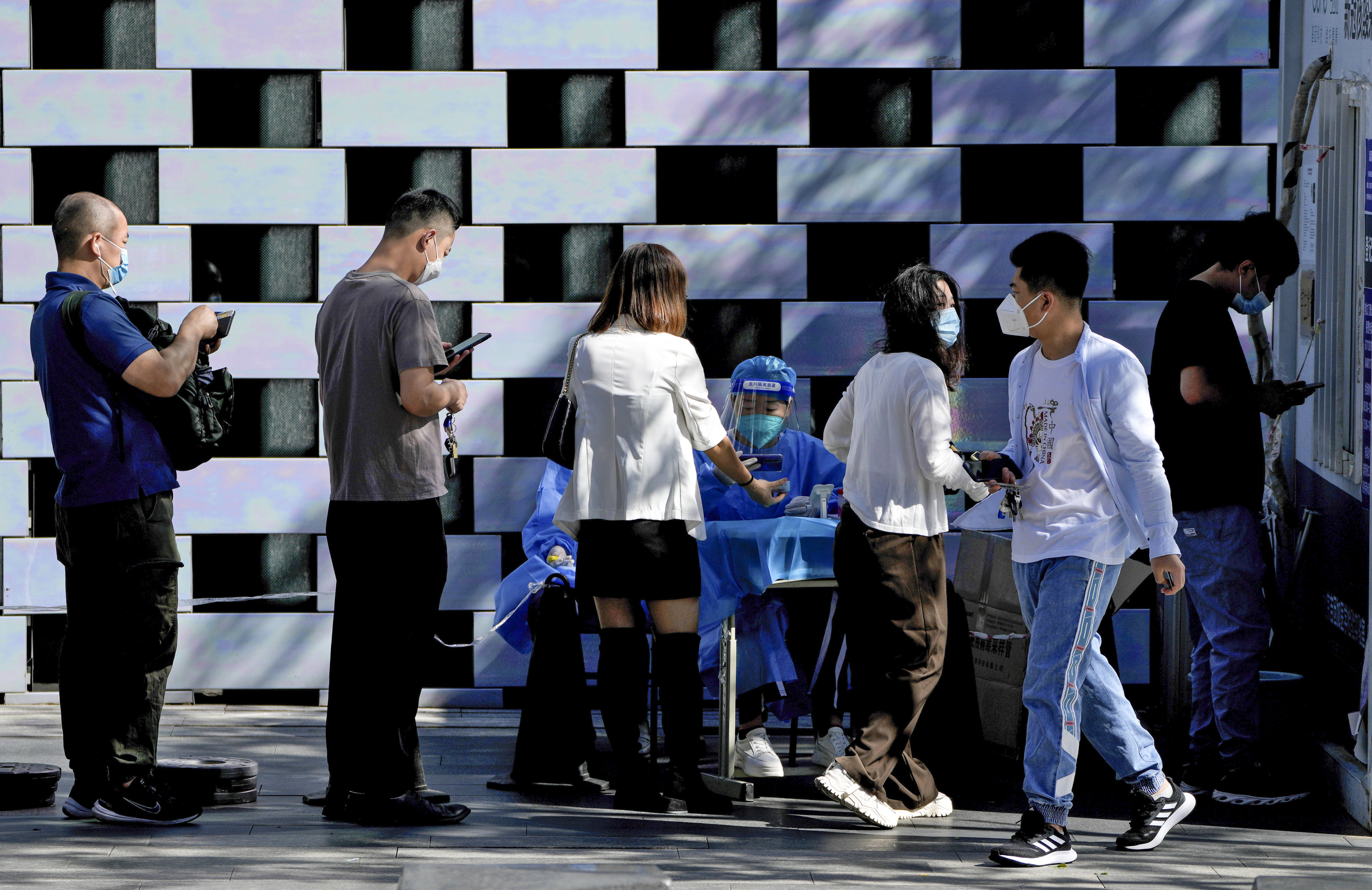 Residents line up to register for routine Covid-19 swabs at a testing site in Beijing on Monday. Photo: AP 
