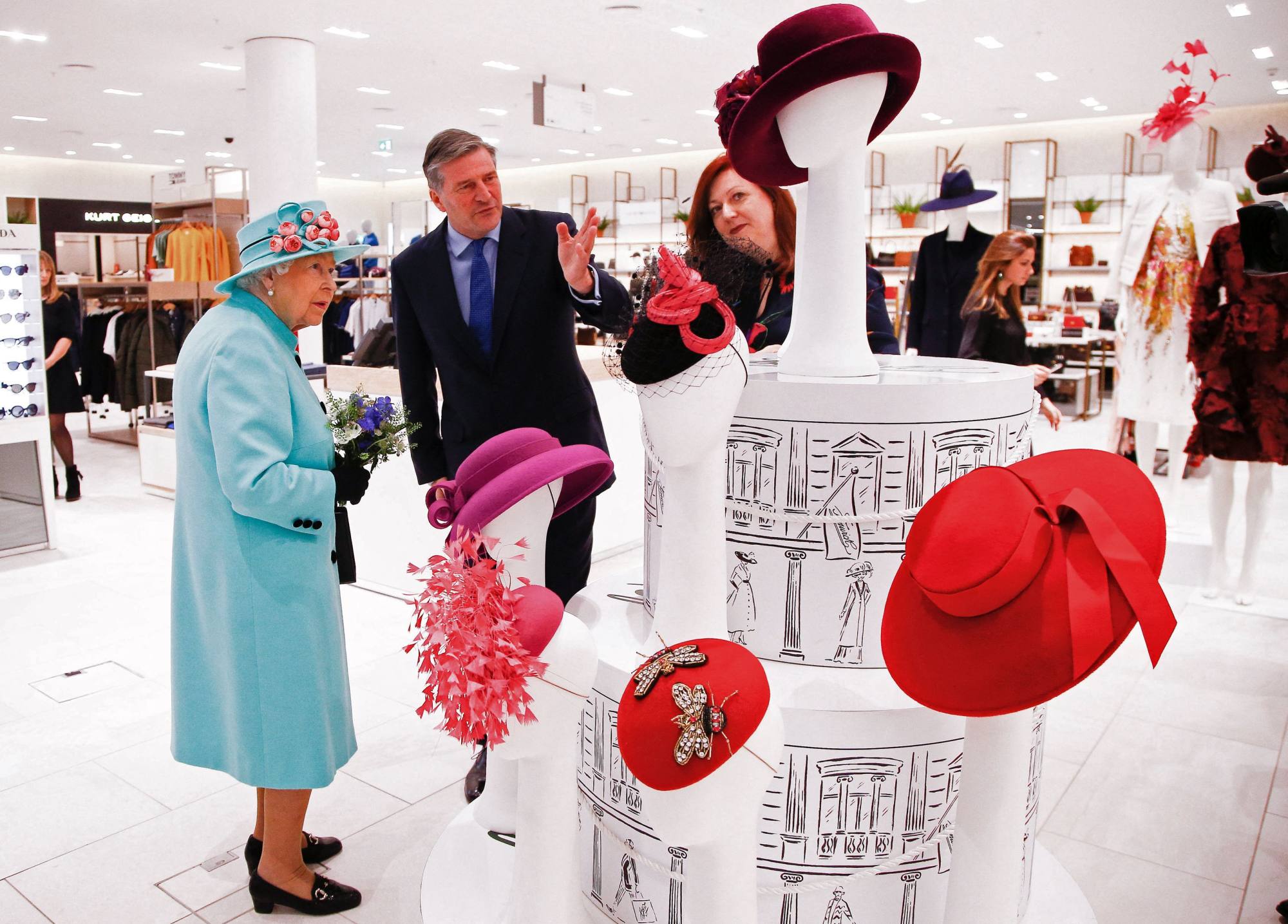 Queen Elizabeth is shown a display of hats as she tours a shopping centre west of London in 2018. She always wore one in public, partly to compensate for being 1.63 metres tall. Photo: AFP/Pool