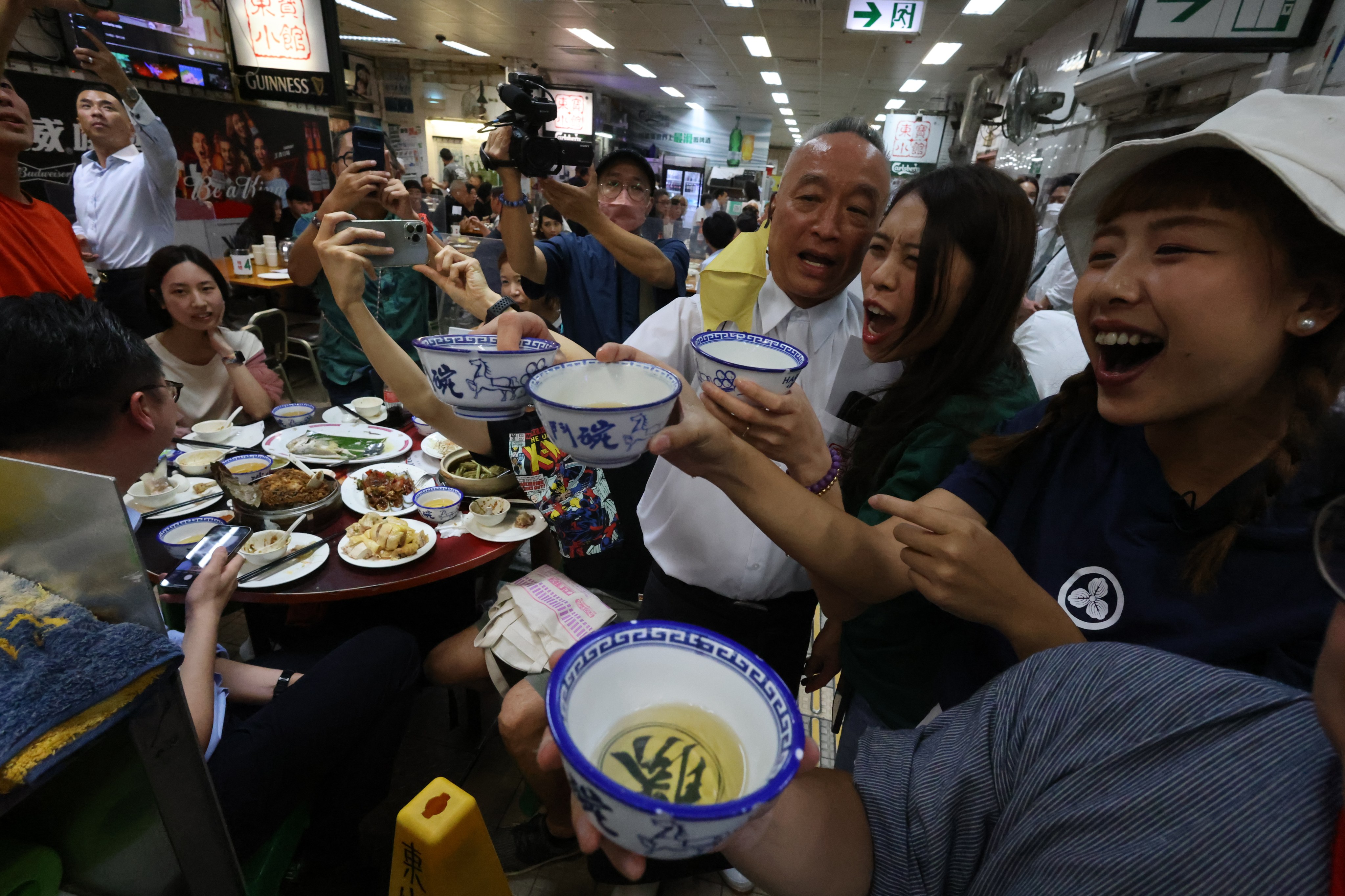 Robby Cheung (centre), co-owner and manager of Tung Po Kitchen, toasts with customers on the second to last night in business at the restaurant at the Java Road Market and Cooked Food Centre, in North Point, Hong Kong. Photo: Dickson Lee