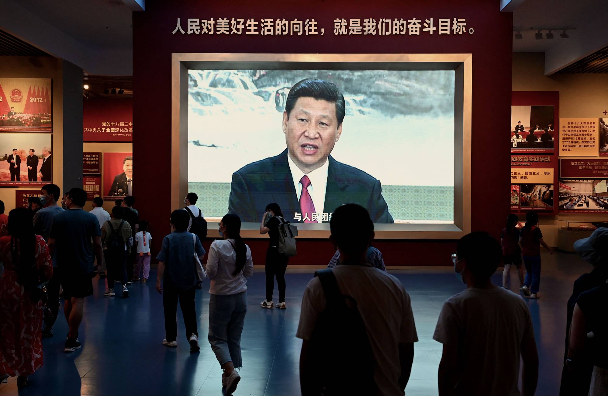 People walk past a screen showing Chinese President Xi Jinping at the Museum of the Communist Party of China in Beijing. Xi is expected to cement his status as paramount leader at next month’s party congress. Photo: AFP