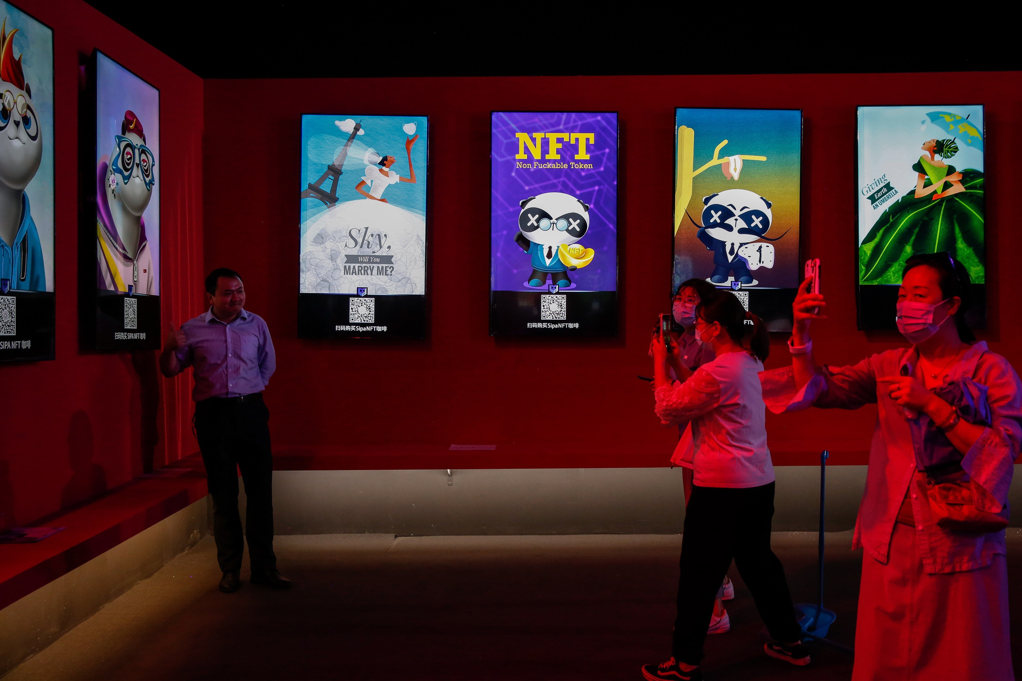 Visitors take photos at an NFT-themed coffee shop during the China International Fair for Trade in Services in Beijing. Photo: EPA-EFE