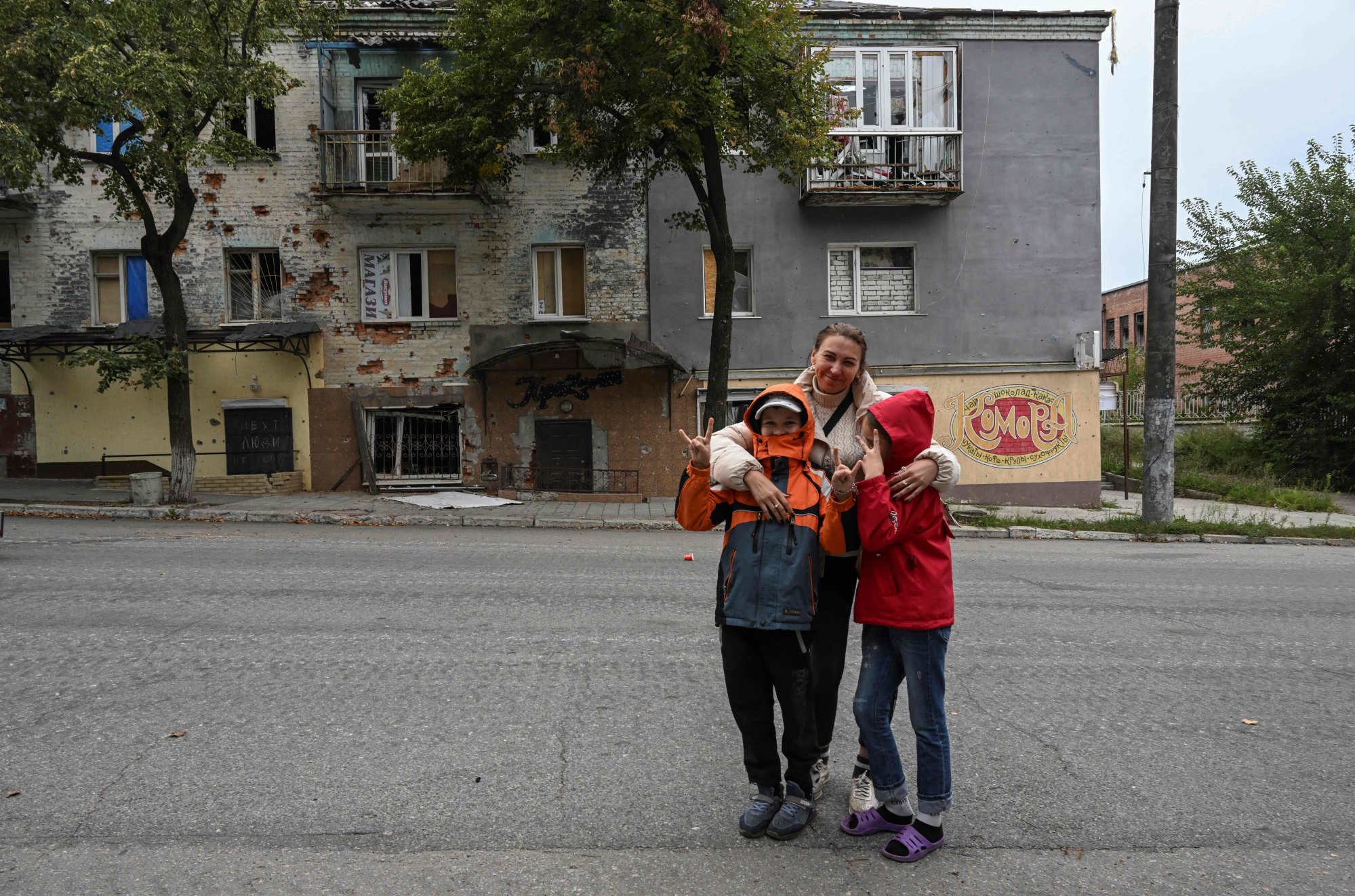 A woman with her children in front of a destroyed building in Izium, Kharkiv region, eastern Ukraine. Photo: AFP