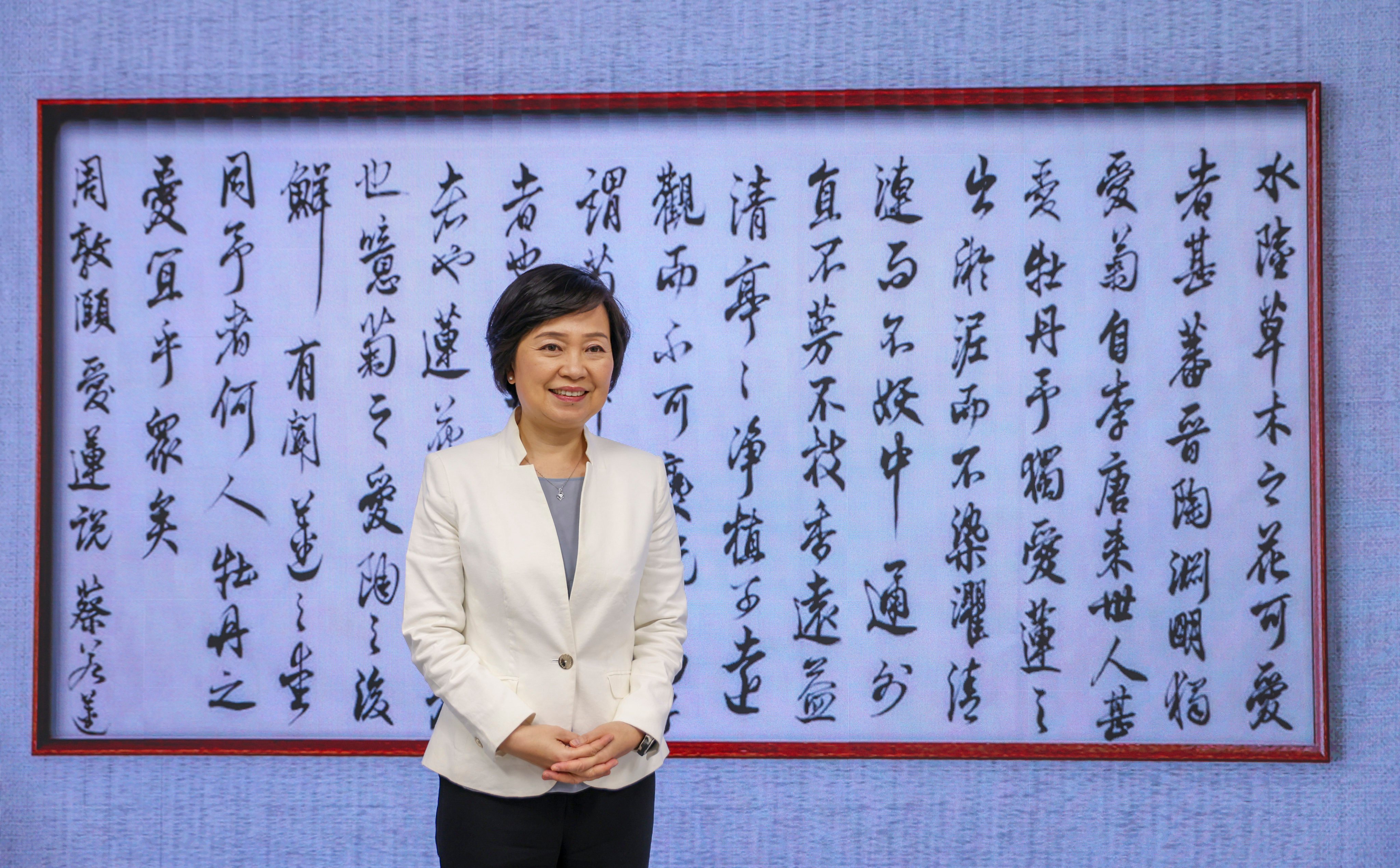 Secretary for Education Christine Choi Yuk-lin poses against a display of her calligraphy (“On the Love of the Lotus” by Zhou Dunyi of the Northern Song Dynasty) at the Education Bureau on July 13. The bureau has been trying to encourage a more efficient Chinese learning environment at school by introducing Mandarin as the teaching language. Photo: Nora Tam