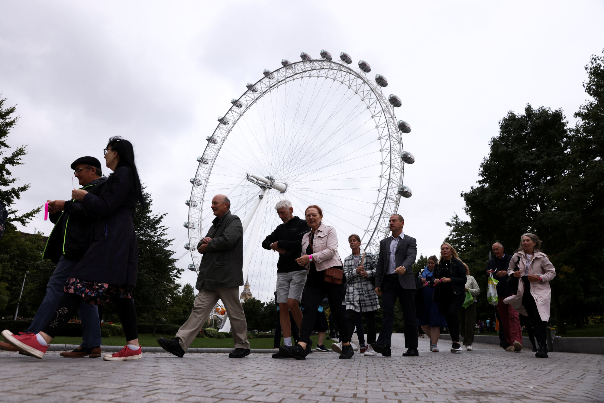 People receive wrist bands near the London Eye on Friday as they gather to pay respects to Britain’s Queen Elizabeth following her death. Photo: Reuters