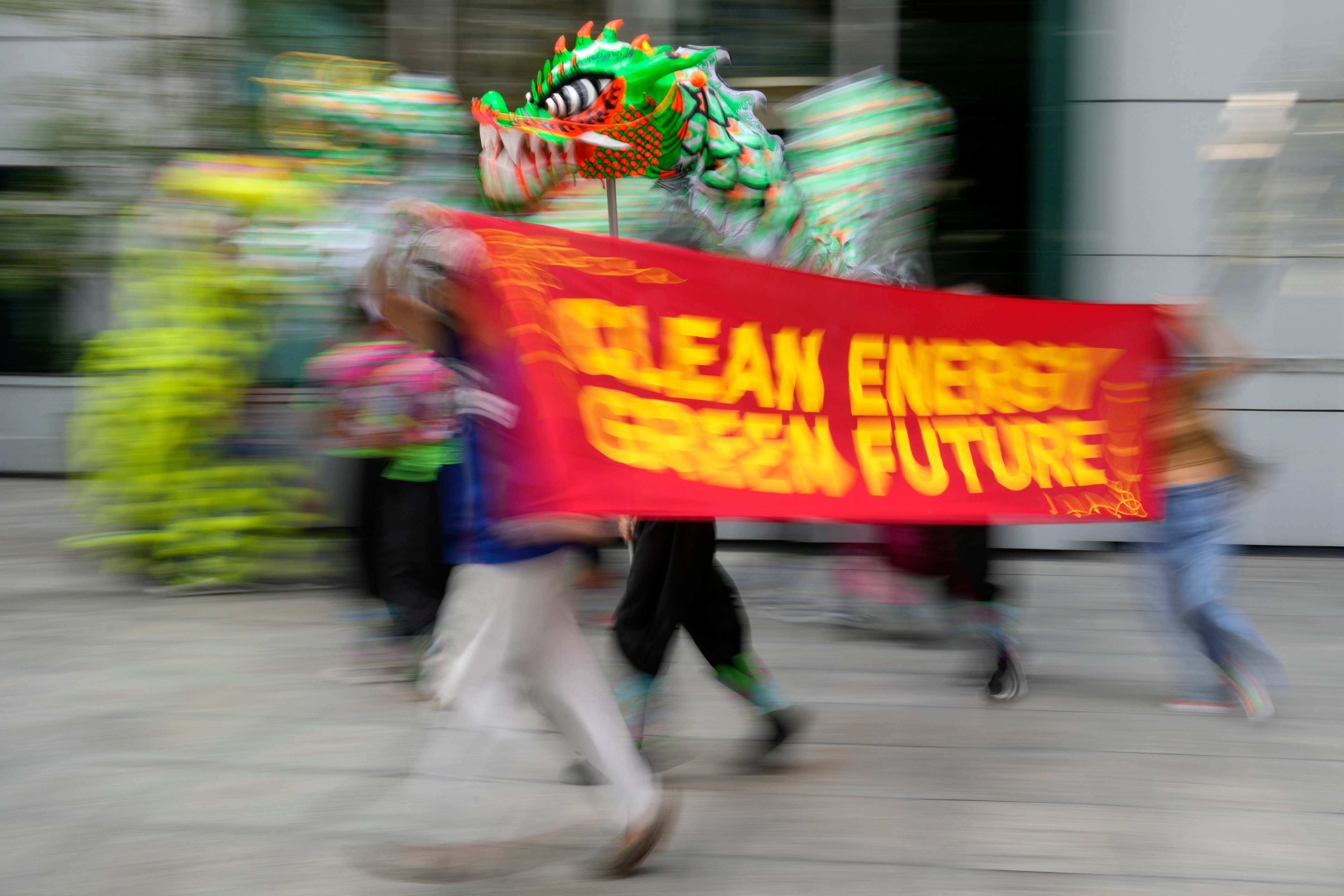 Filipino climate activists run with a banner saying “Clean Energy, Green Future” during a rally outside the Chinese consulate in Makati, Philippines, in October 2021. The group welcomed the announcement by Chinese President Xi Jinping that his country will no longer fund coal-fired plants abroad. Photo: AP