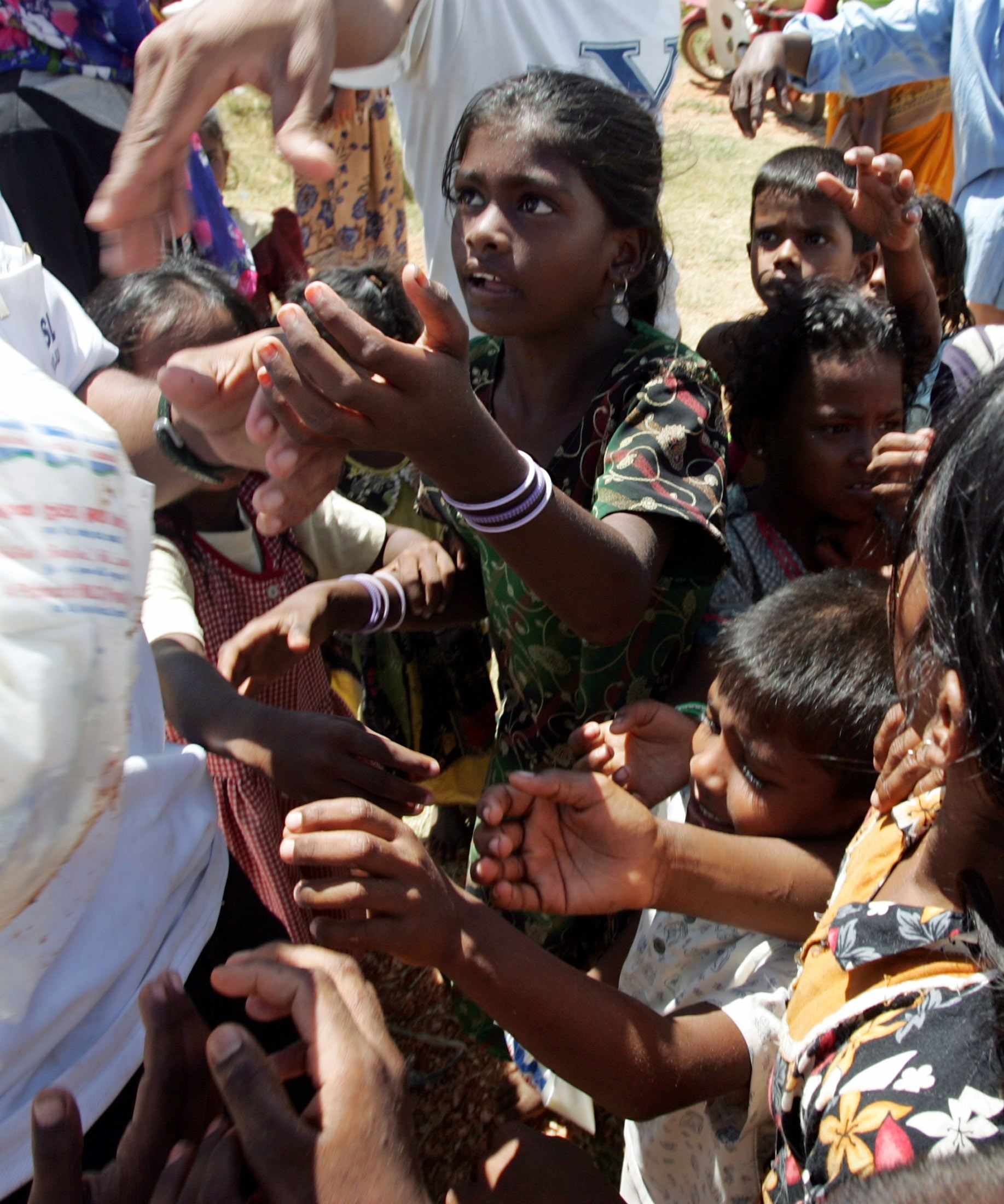 Muslim children in Sri Lanka, fleeing from civil war fighting in 2006, collect food at a refugee camp. Photo: Reuters