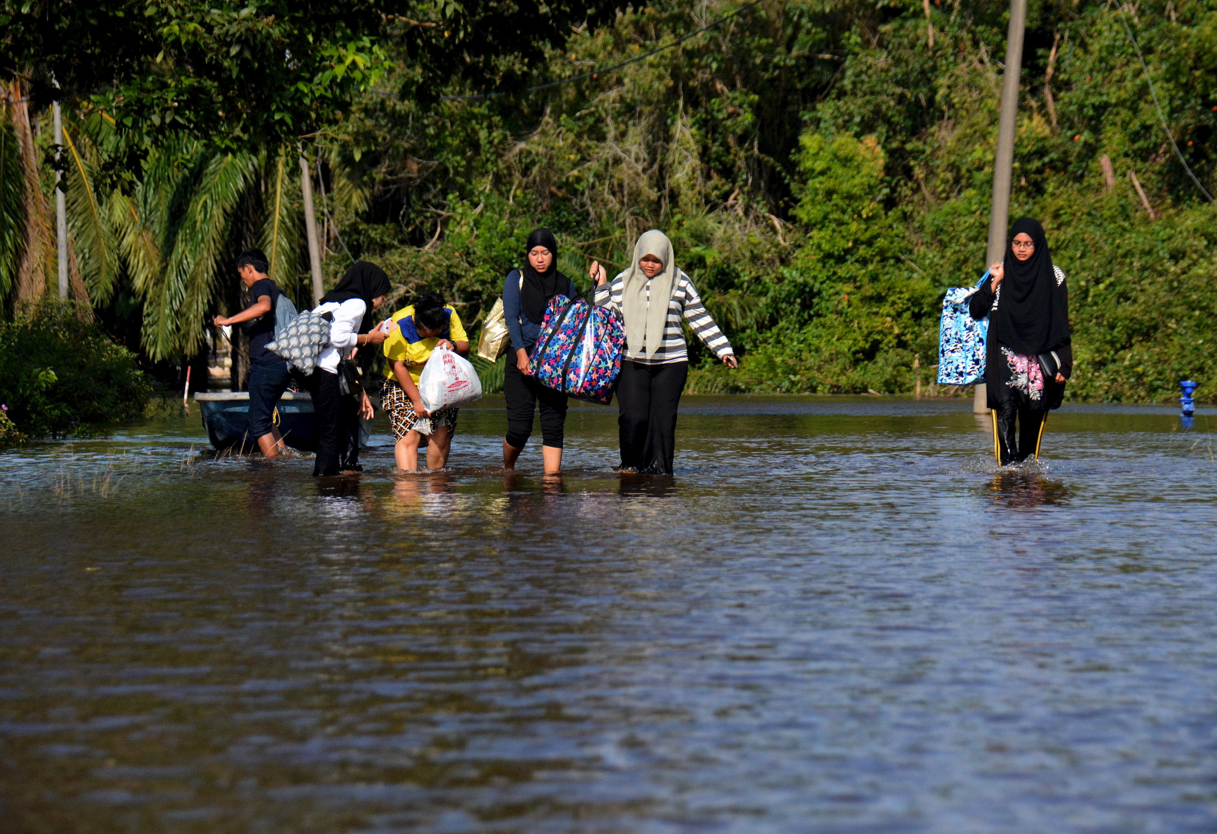 Residents walk in a flooded street in Pahang on their way to a temporary evacuation centre in December 2021. Photo: Bernama/dpa