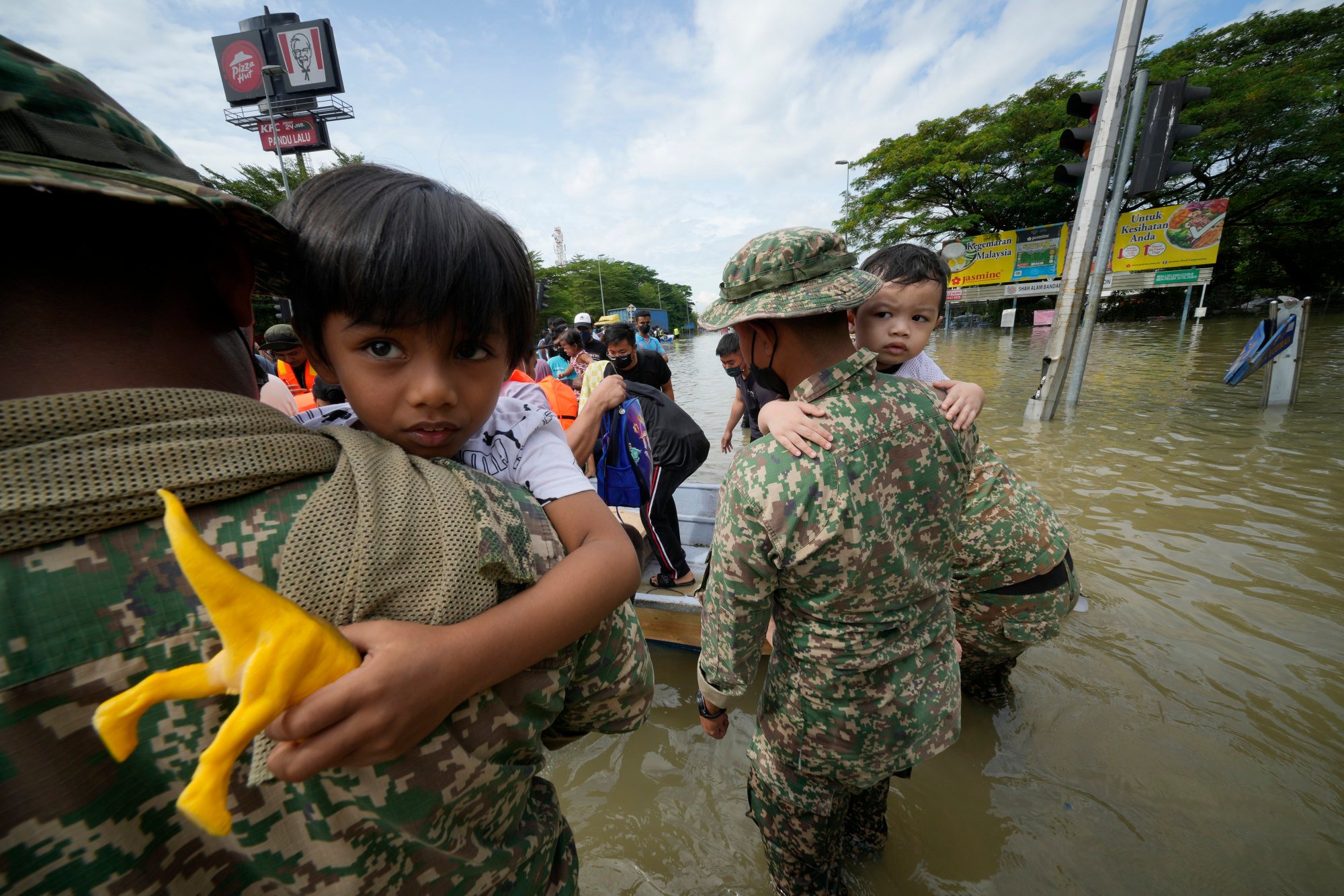Army soldiers rescue children from their house affected by a flood in Shah Alam on December 20, 2021. Photo: AP
