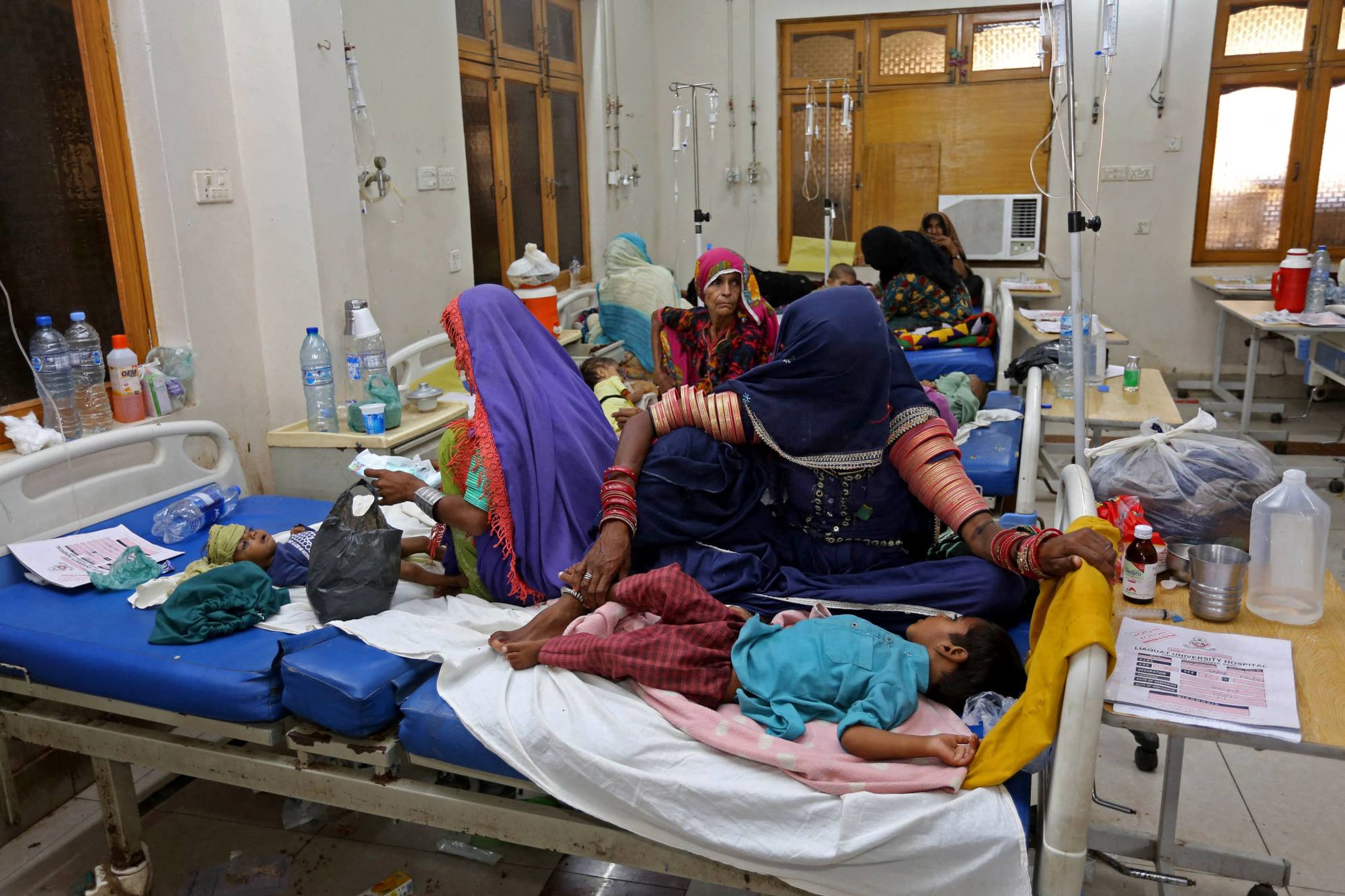 Internally displaced people take care of their children under treatment for malaria and gastro in the flood-hit Hyderabad city of Sindh province earlier this month. Photo: AFP