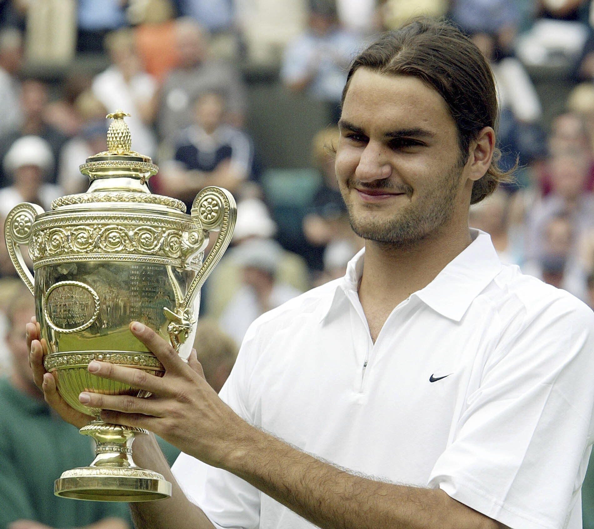 Switzerland’s Roger Federer holds the men’s singles trophy after defeating Australia’s Mark Philippoussis in the 2003 Wimbledon final. Photo: AP