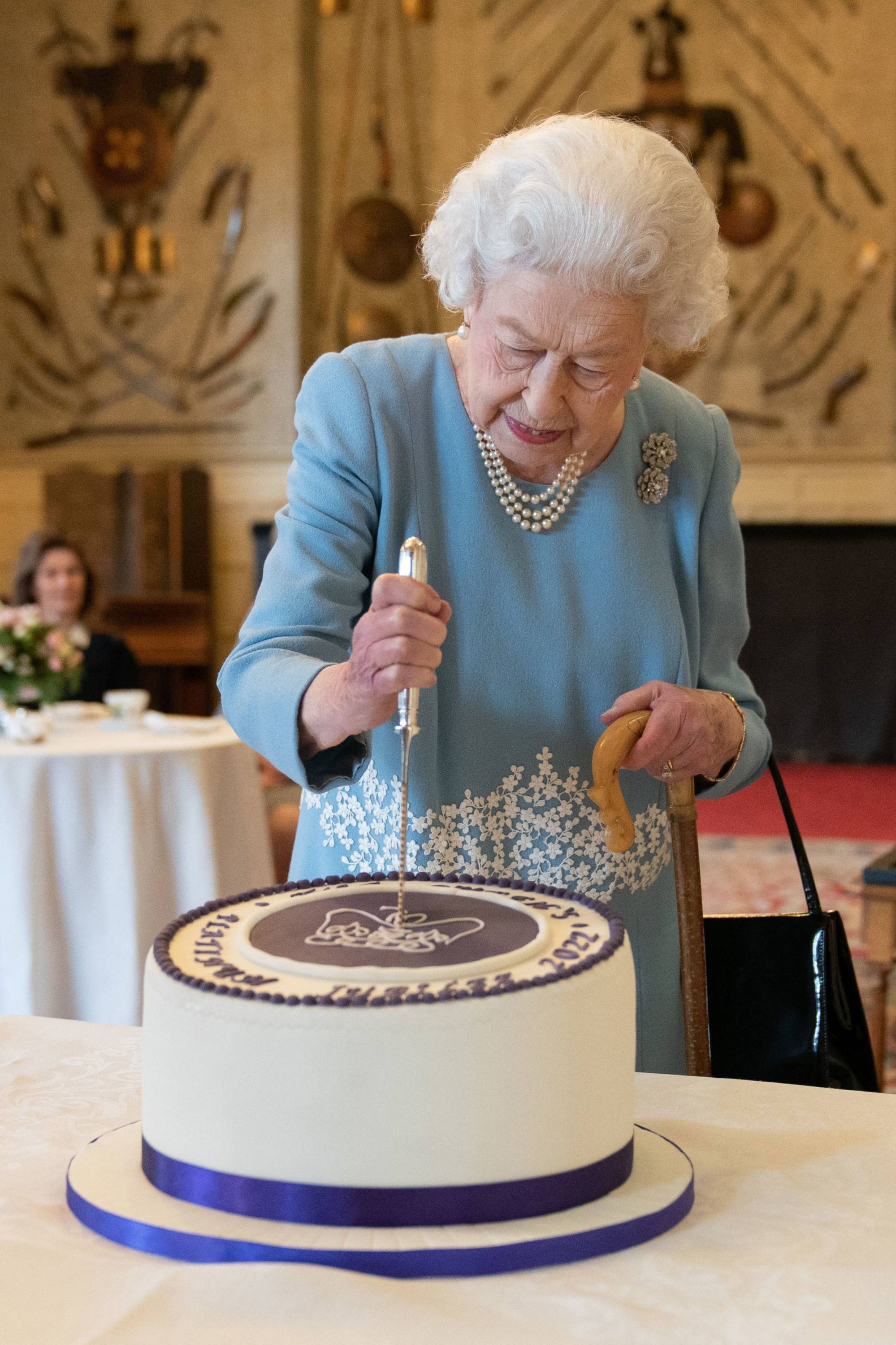 Queen Elizabeth cuts a cake to celebrate the start of her Platinum Jubilee at Sandrringham House, Norfolk, eastern England on February 5, 2022. Photo: Pool/AFP
