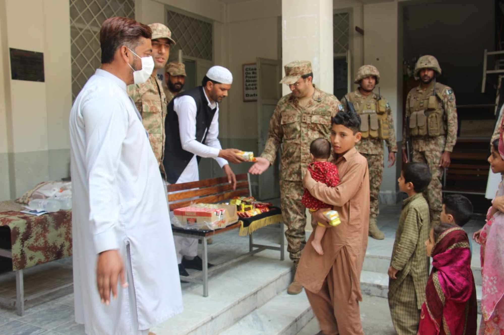 Flood affected children receive glucose biscuits from Pakistani soldiers in Swat. Photo: Pakistan Inter Services Public Relations