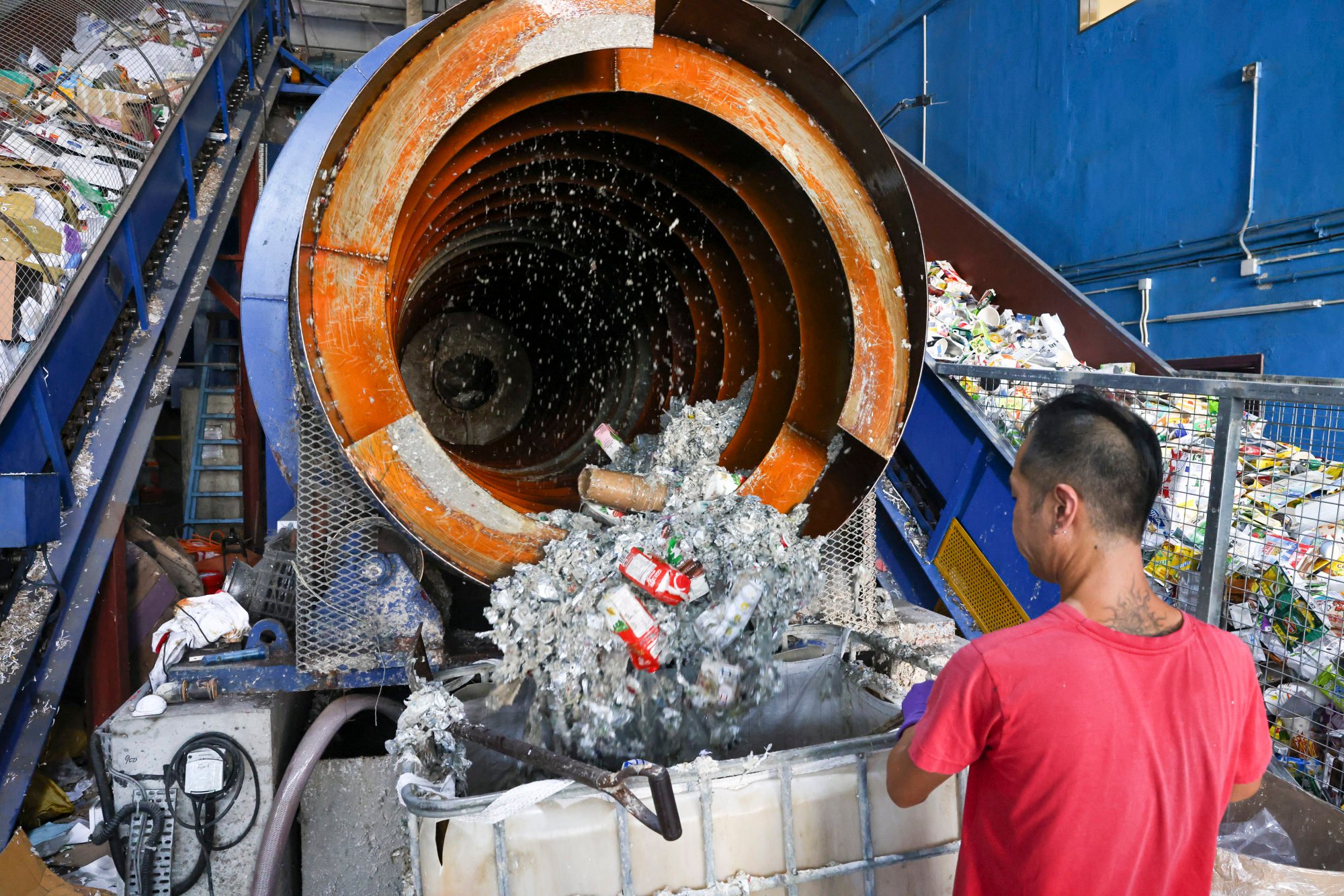 A worker at Mil Mill operates a recycling machine that converts drinks cartons and other paper waste into products such as cardboard, building materials and cat litter. Photo: K. Y. Cheng