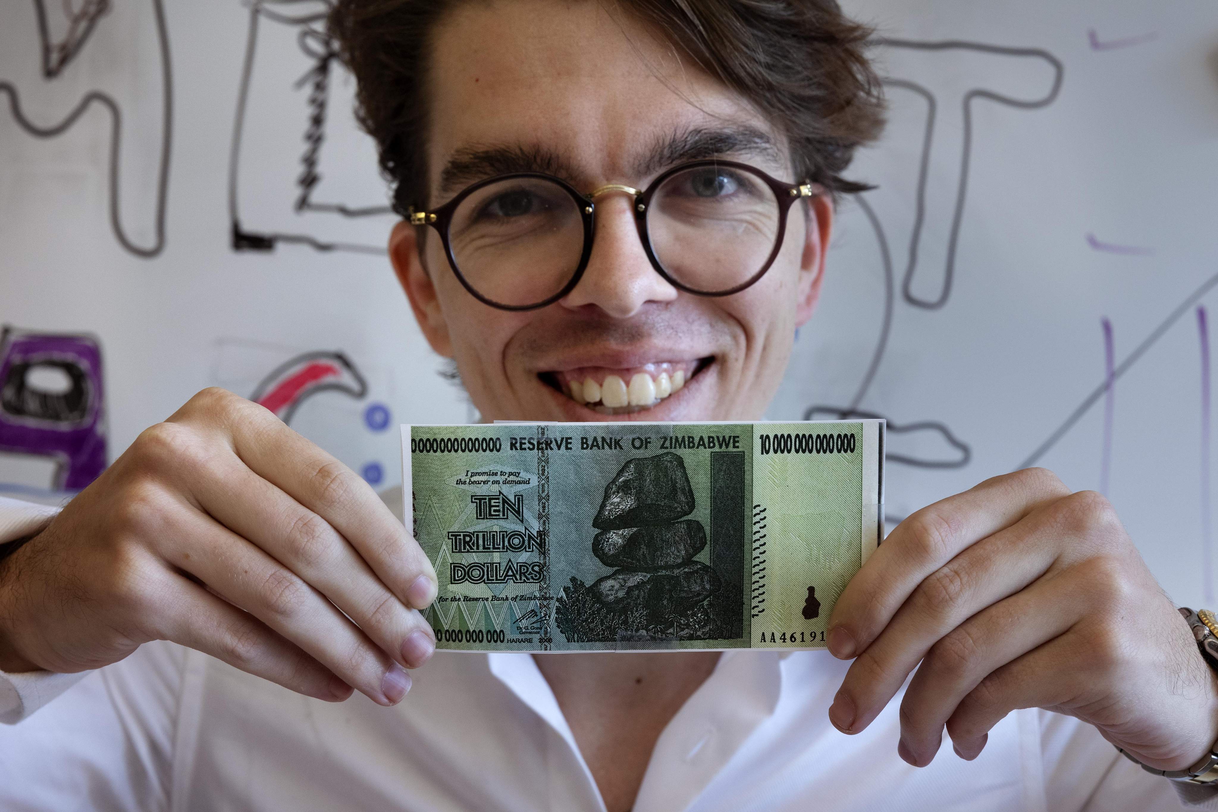 Eric Martinez, a graduate student in the brain and cognitive science department at the Massachusetts Institute of Technology, holding a Zimbabwean 10 trillion dollar bill on Sept 9. Martinez shares the Ig Nobel literature prize for research on what makes legal documents unnecessarily difficult to understand. Photo: AP