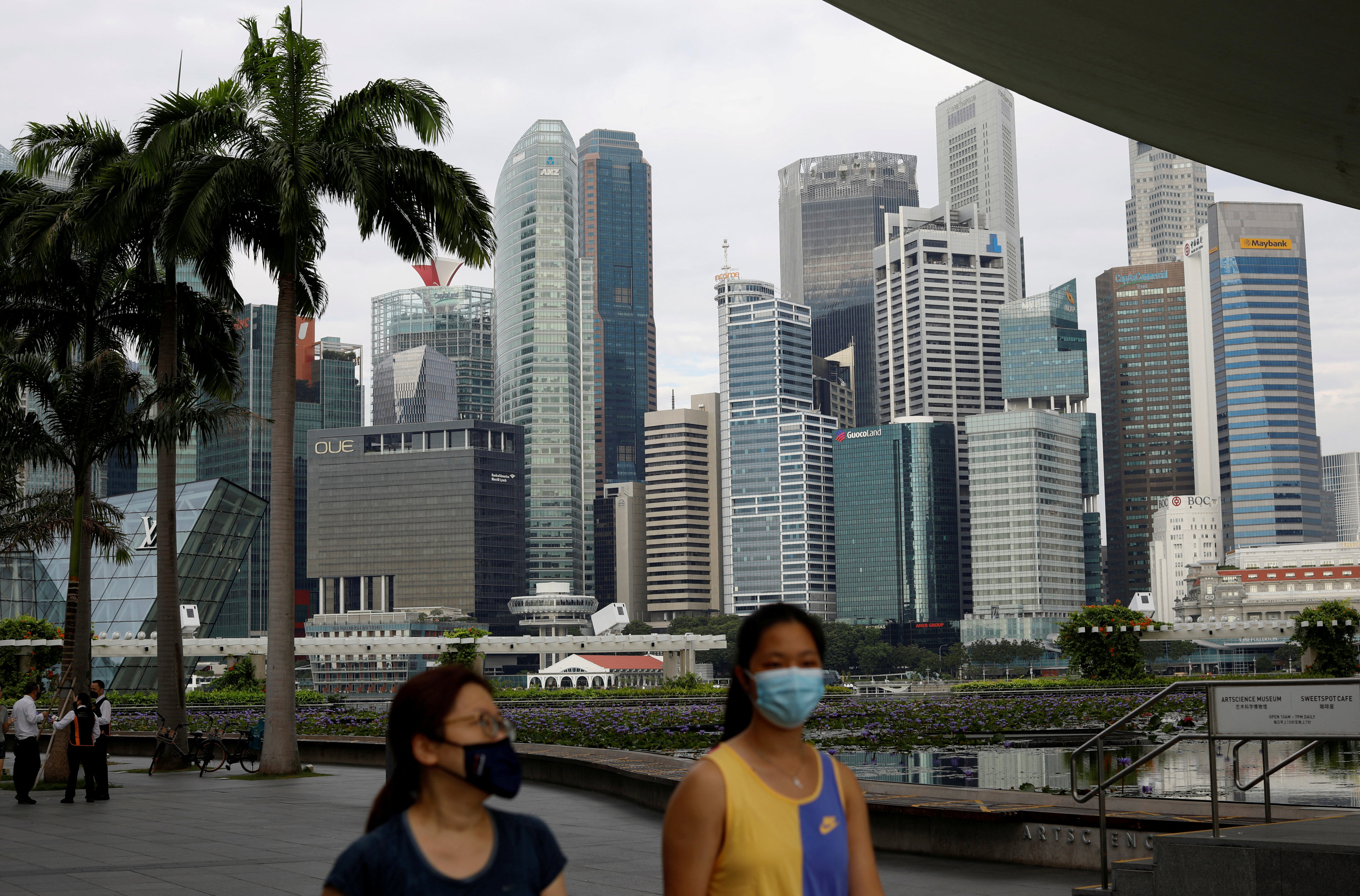 People wearing face masks walk through Singapore last year amid the pandemic. Photo: Reuters